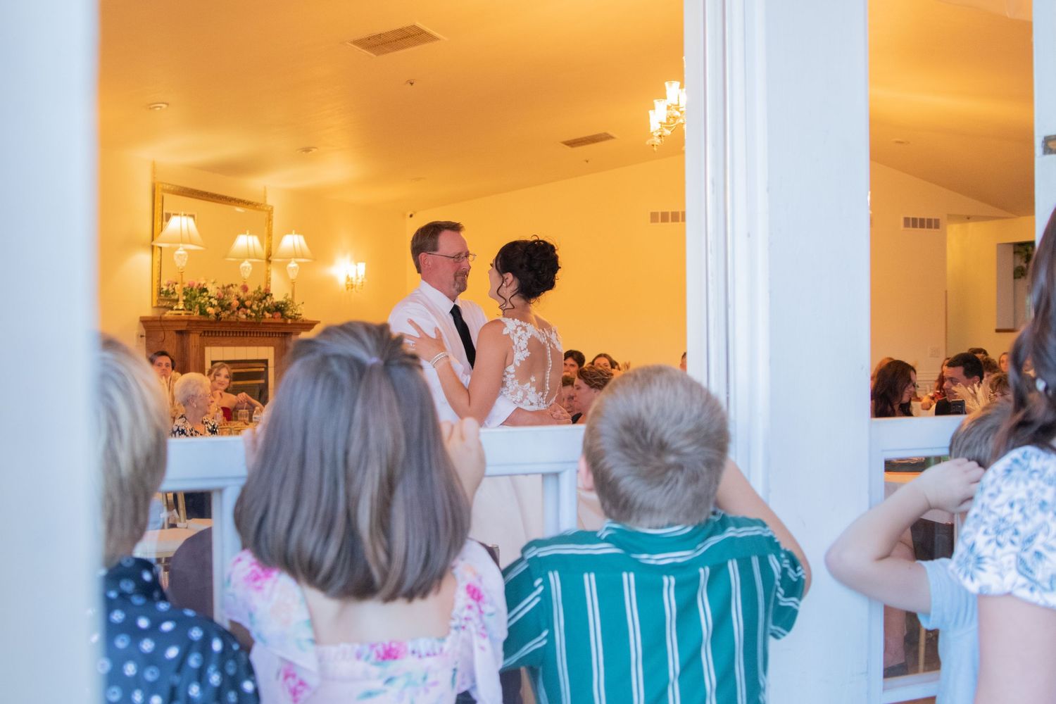 Wedding reception venue with white columns and guests seated at decorated tables.
