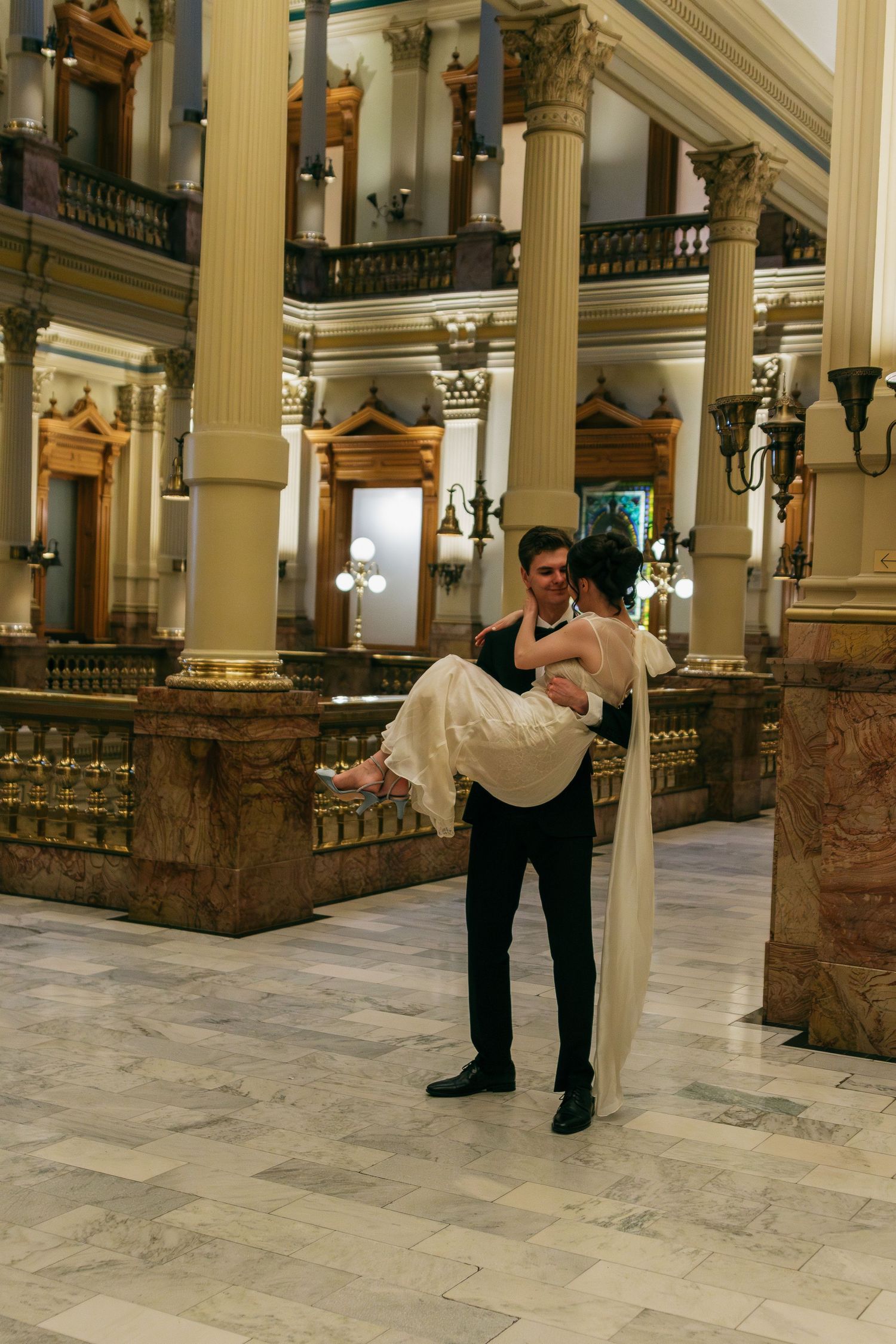 Elegant marble hall with classical columns and ornate architectural details in warm lighting.
