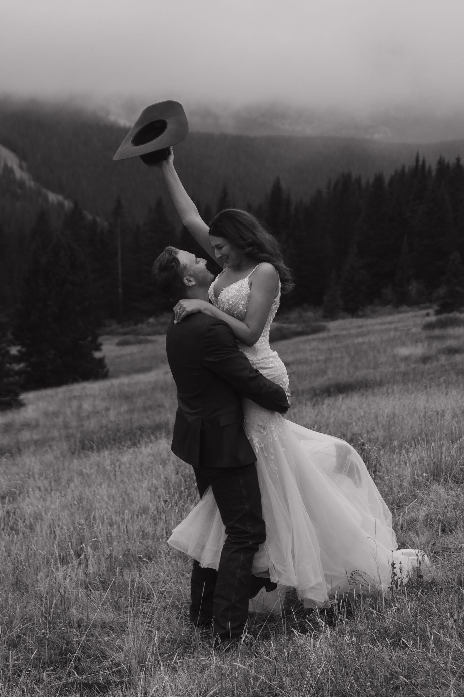 Black and white photos capture romantic dance moments between newlyweds in a mountain field.