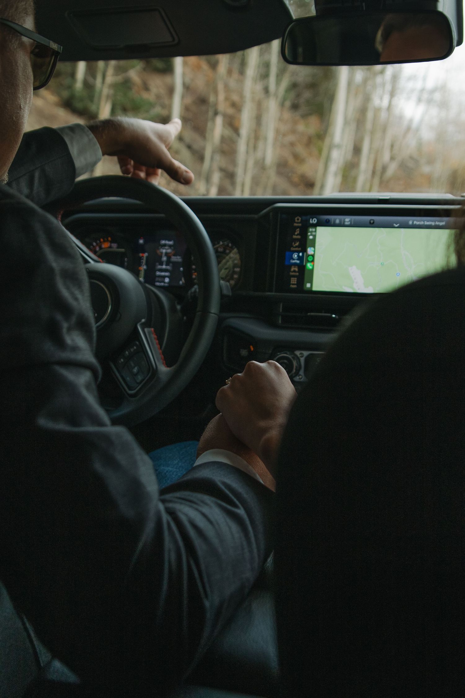 Interior view of someone adjusting settings in a car dashboard.