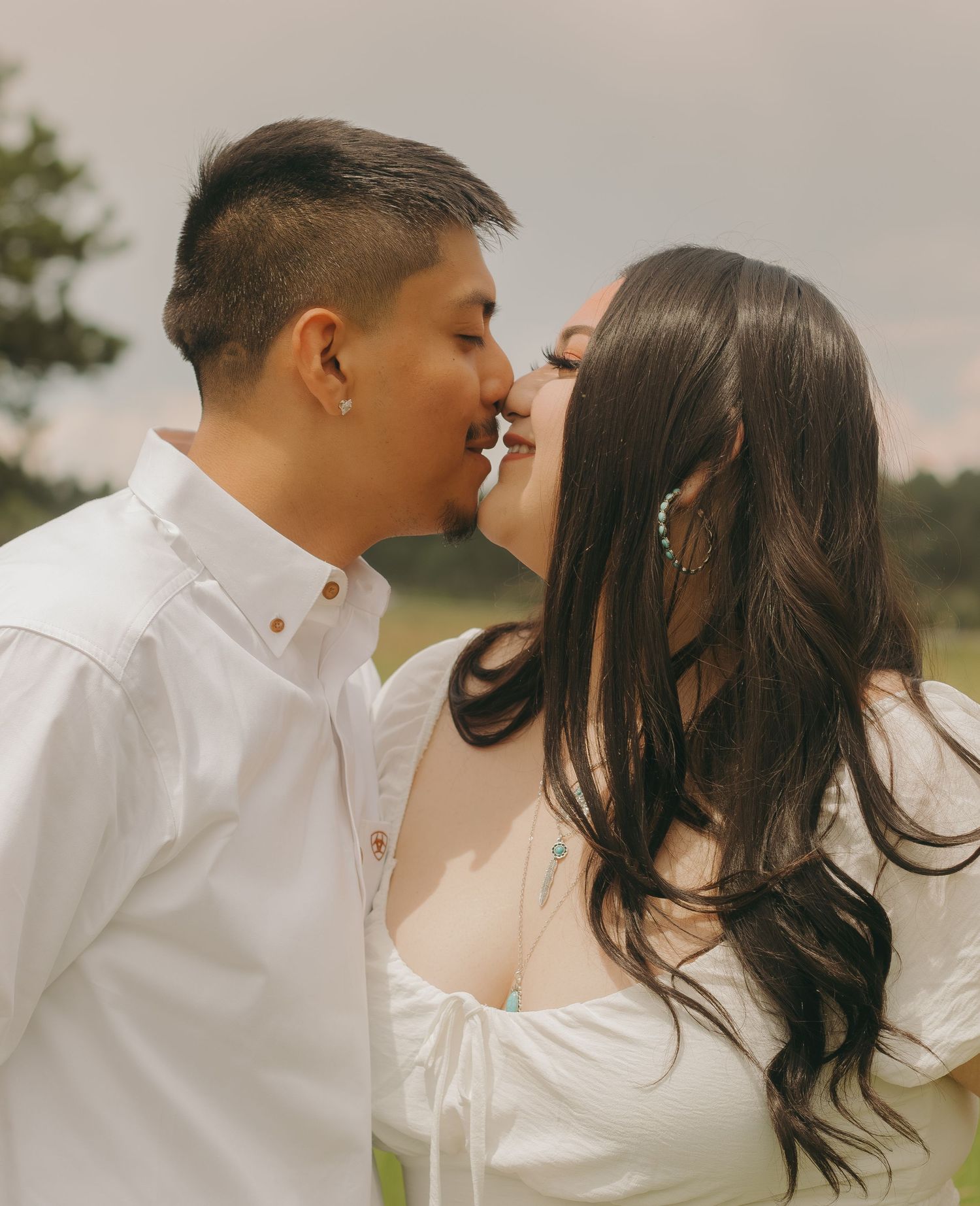 Intimate close-up of a couple about to kiss in an outdoor setting.