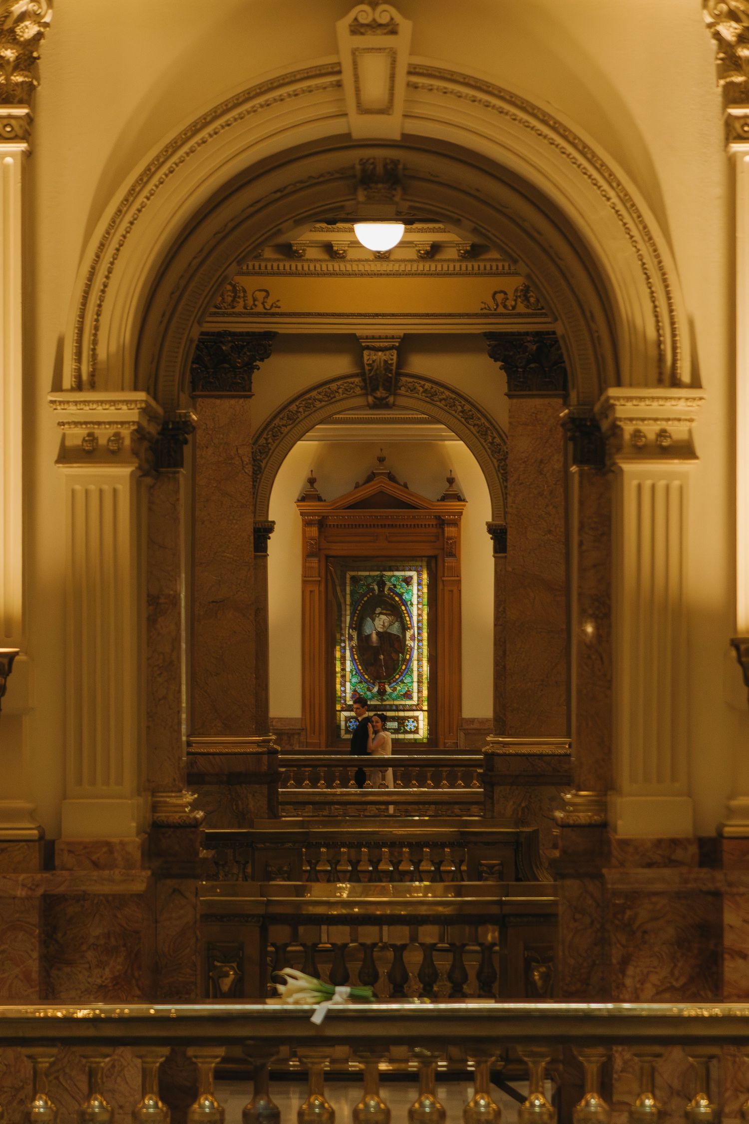 A warmly lit architectural interior featuring ornate arches and decorative columns.