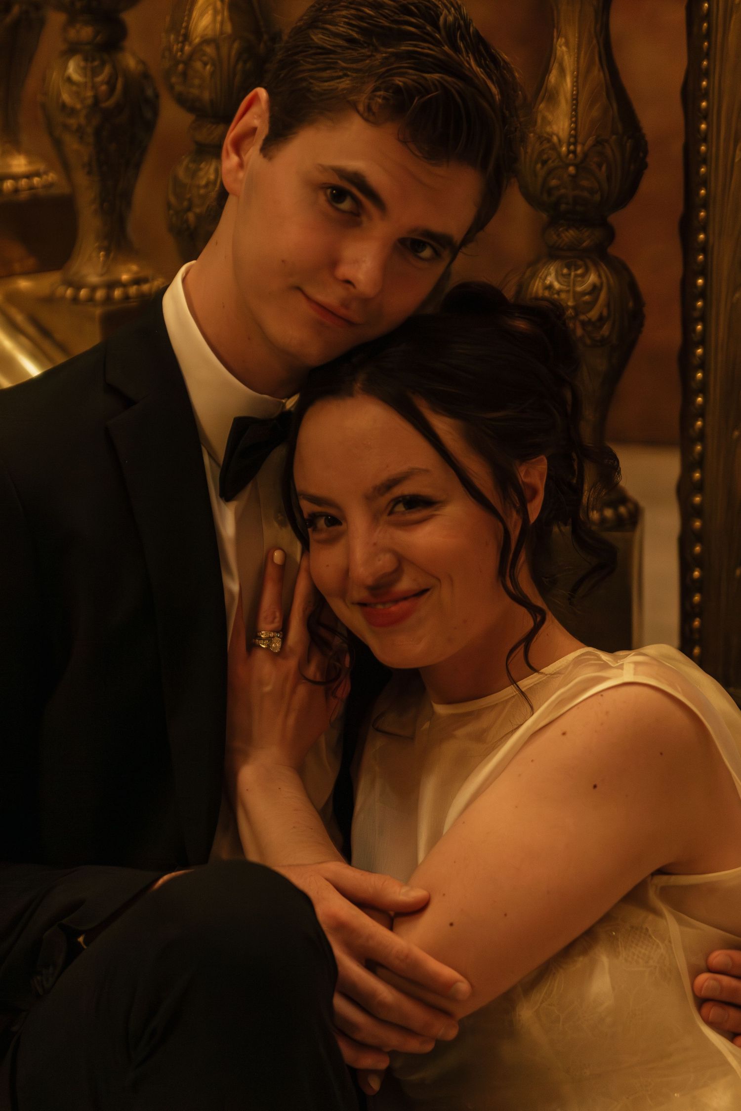 A romantic sepia-toned wedding portrait captured in an ornate vintage setting.