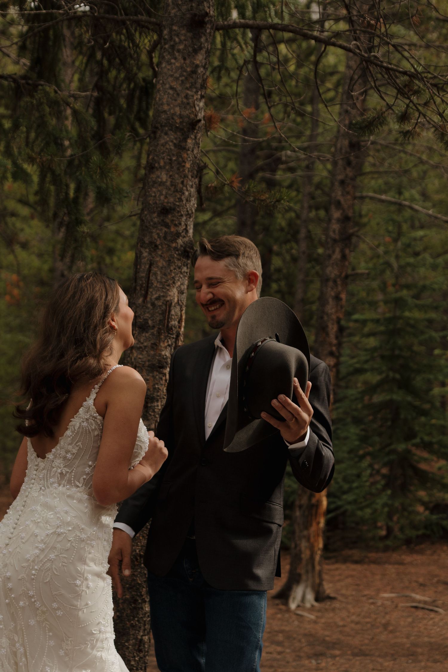 A romantic moment between newlyweds in a rustic forest wedding setting.