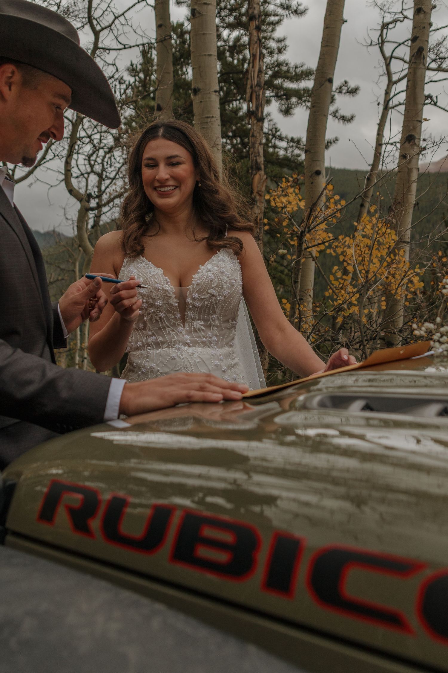 Wedding celebration at a rustic outdoor table with mountains in the background.