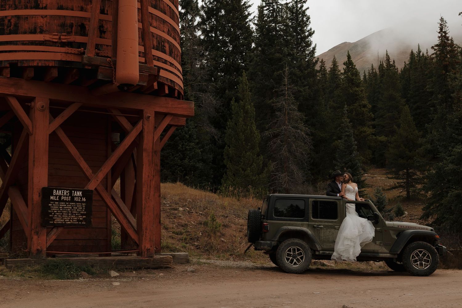 A rustic mountain lodge venue with vehicles parked outside during a wedding celebration.
