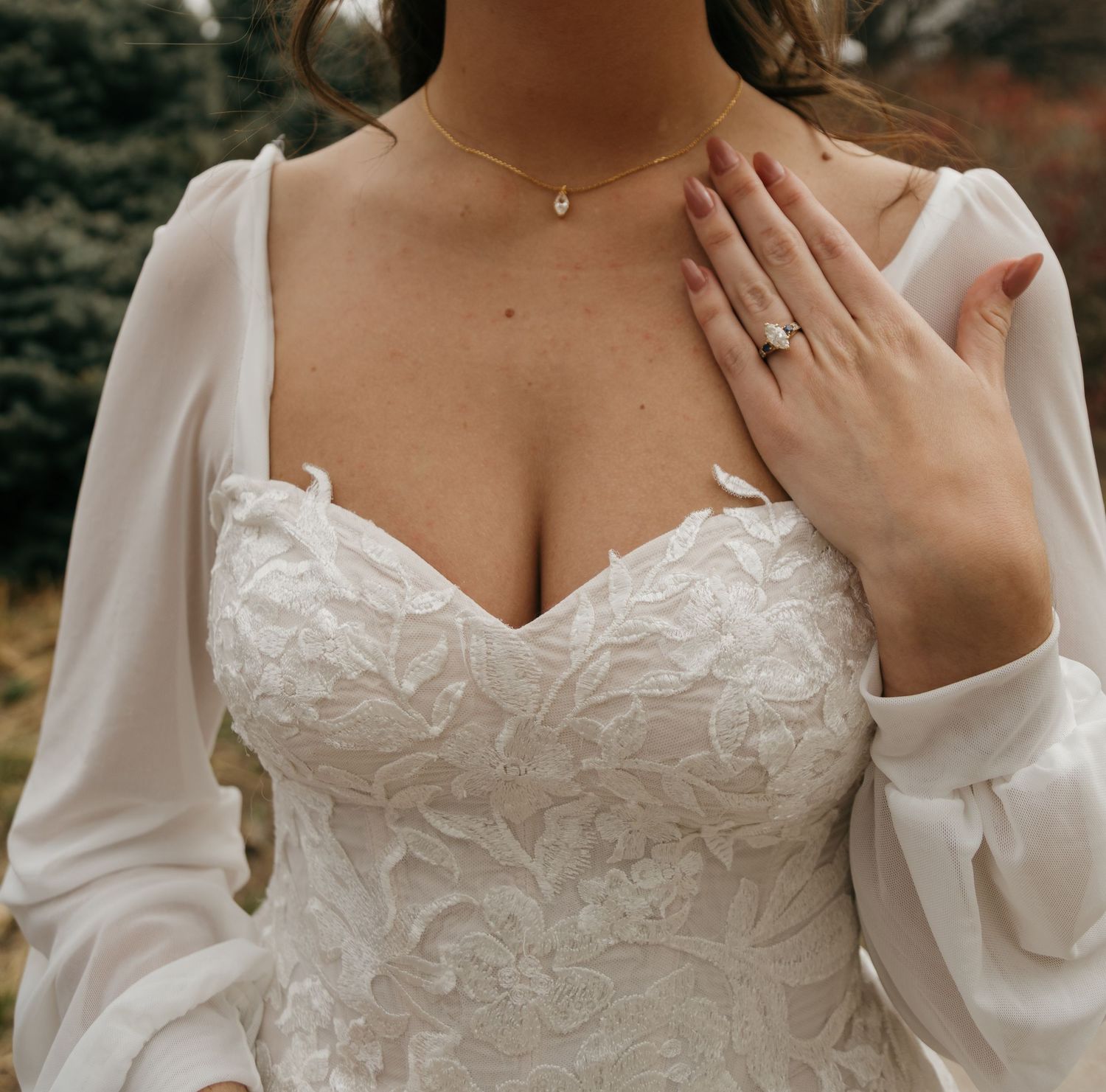 Close-up details of a white lace wedding dress with delicate embroidery and long bishop sleeves.