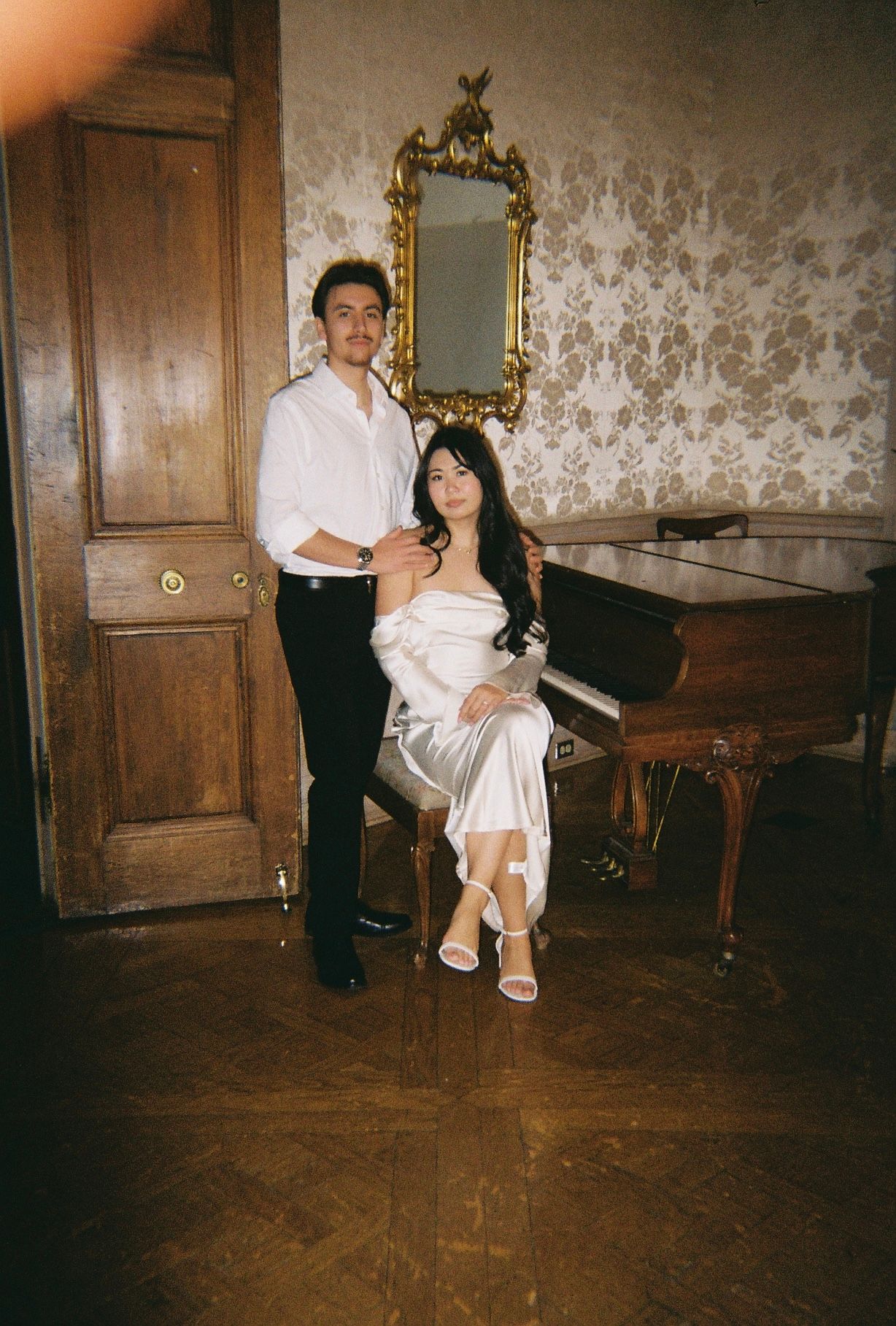 A romantic scene in a vintage room with antique piano and patterned wallpaper.