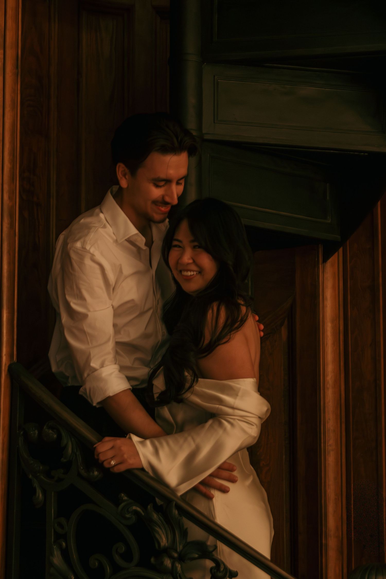 A romantic moment captured in a dimly lit wooden interior space.