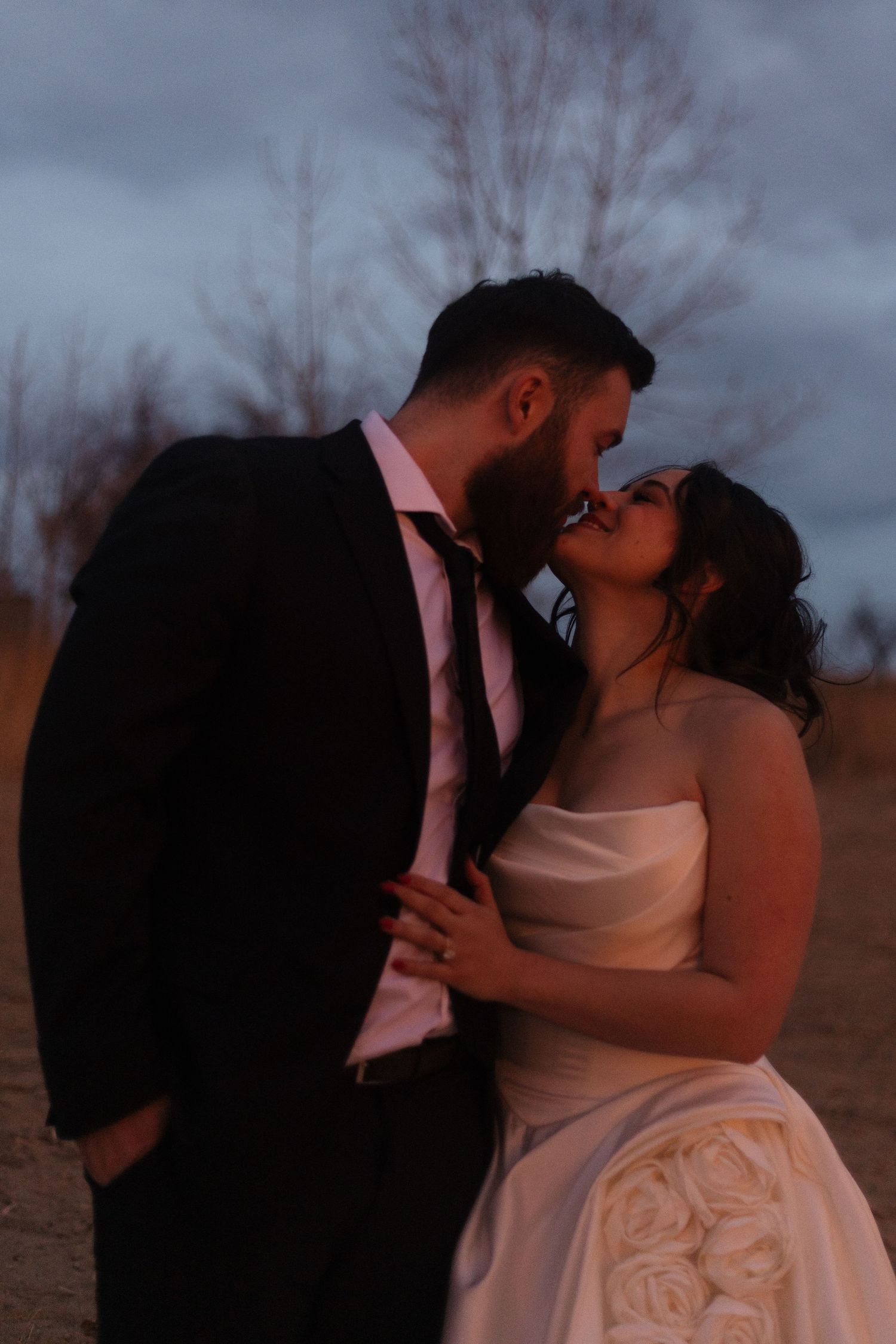 A romantic sunset wedding portrait captured against a moody winter sky.