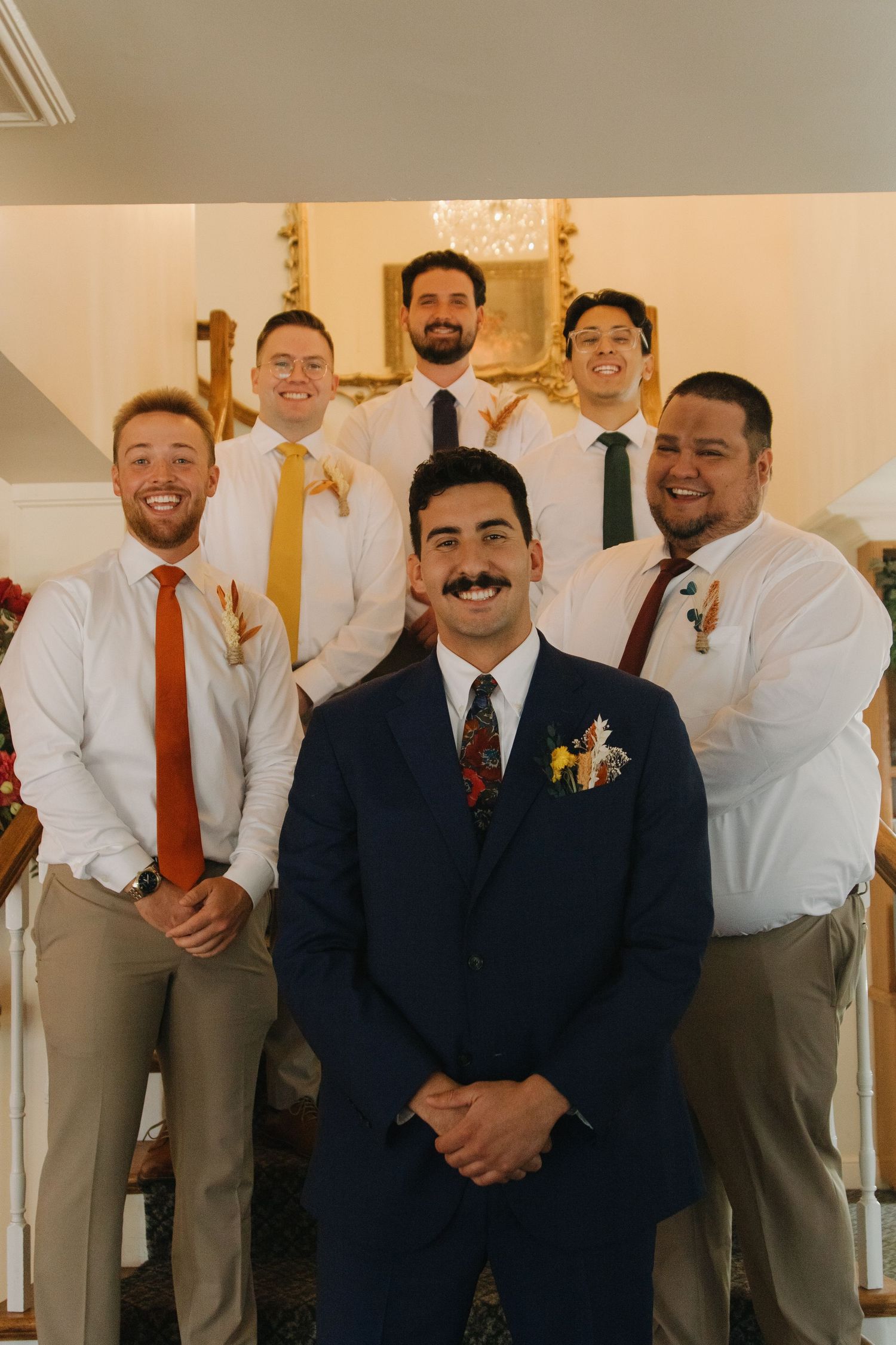 Groomsmen in formal attire gathering for group photos at wedding celebration.