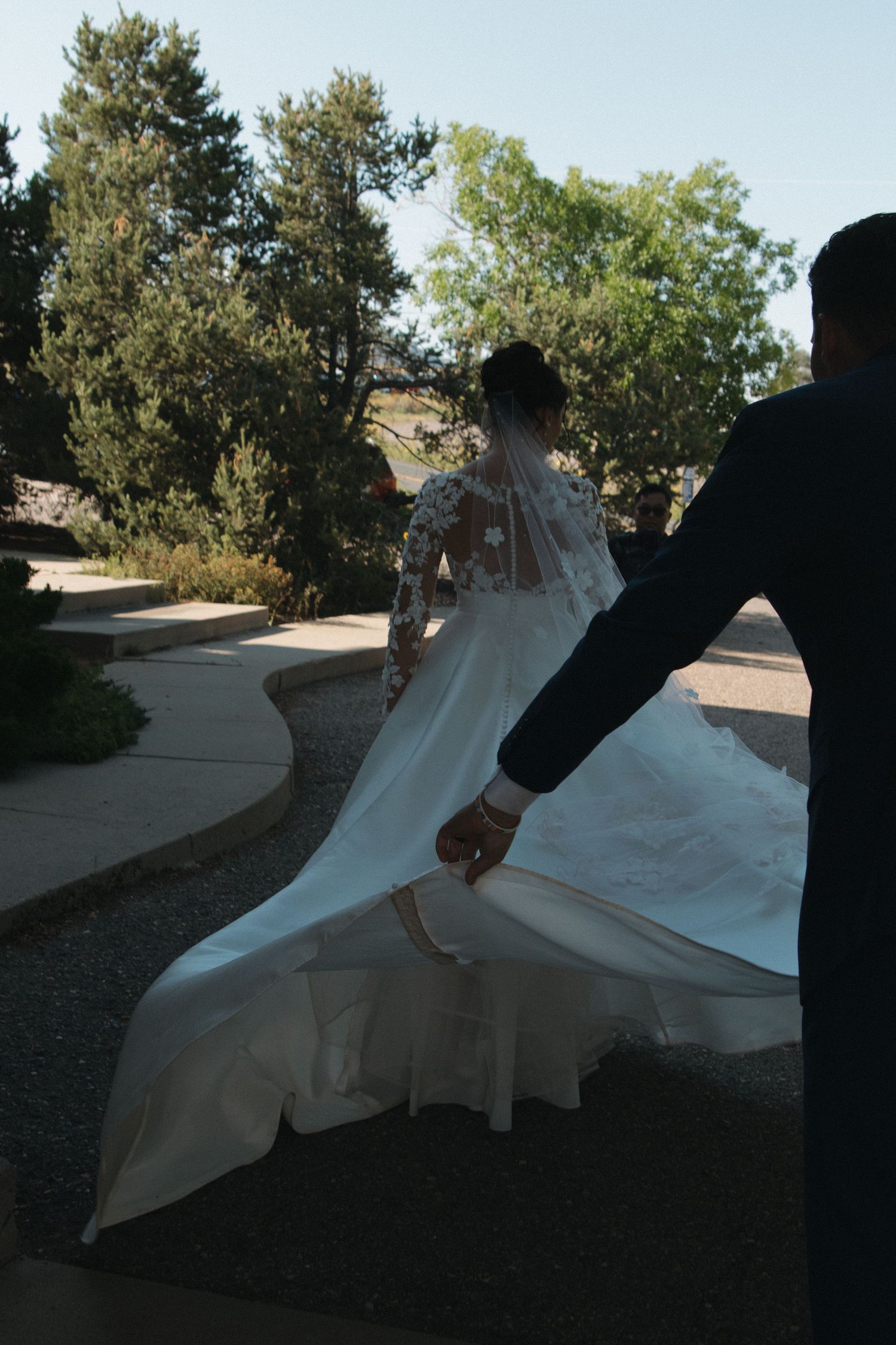 Silhouettes capture the dramatic movement of a wedding dress against the setting sun.