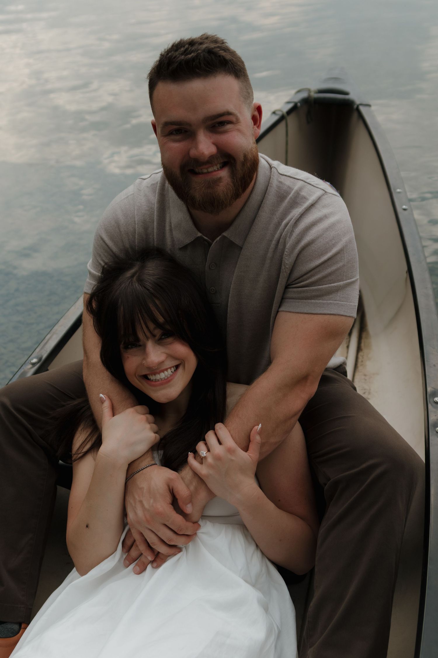 A couple sharing a tender embrace and laughter together during an intimate photoshoot.