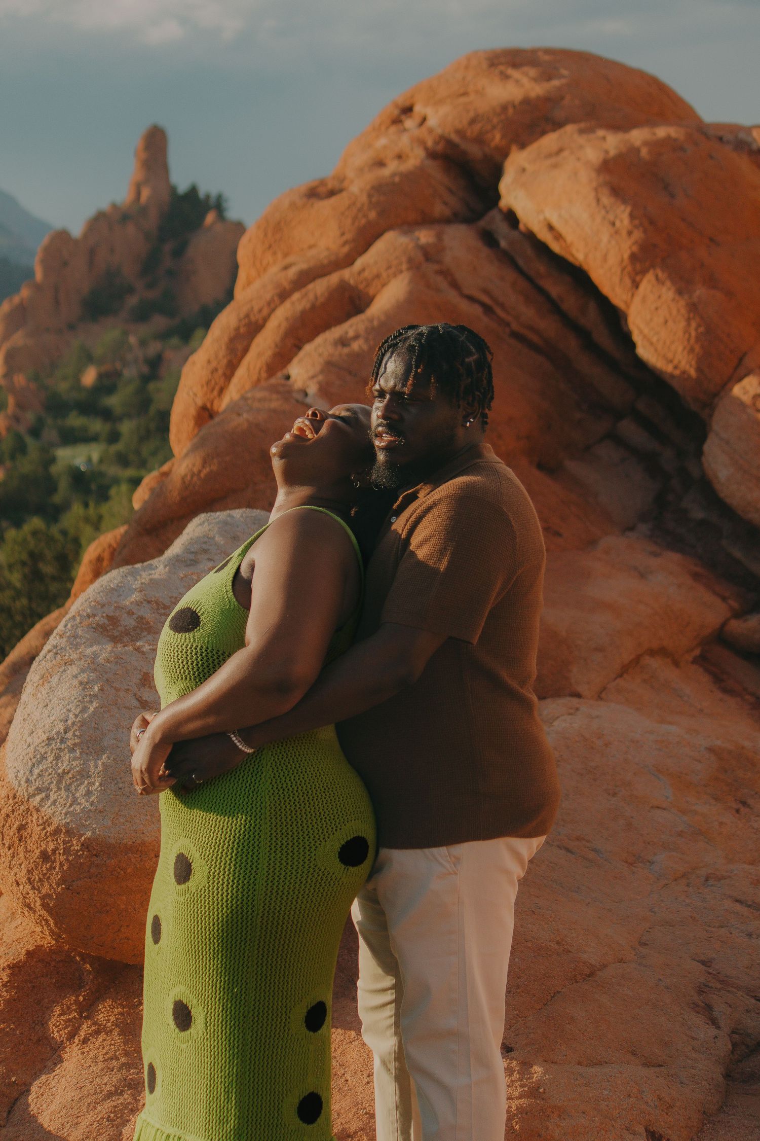 A couple shares an intimate moment against the stunning backdrop of red rock formations.