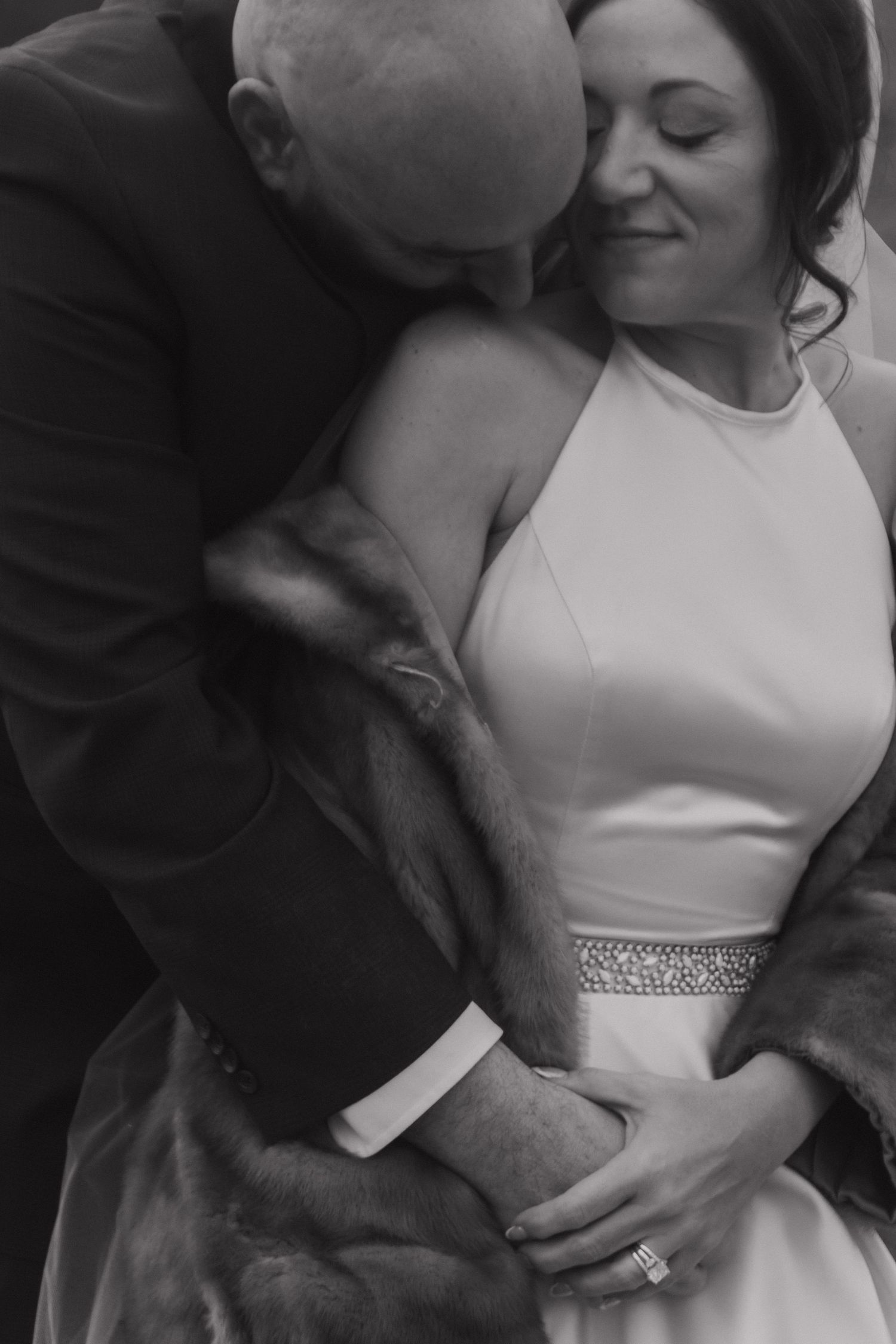 A romantic black and white photo series showing tender moments between a couple on their wedding day.