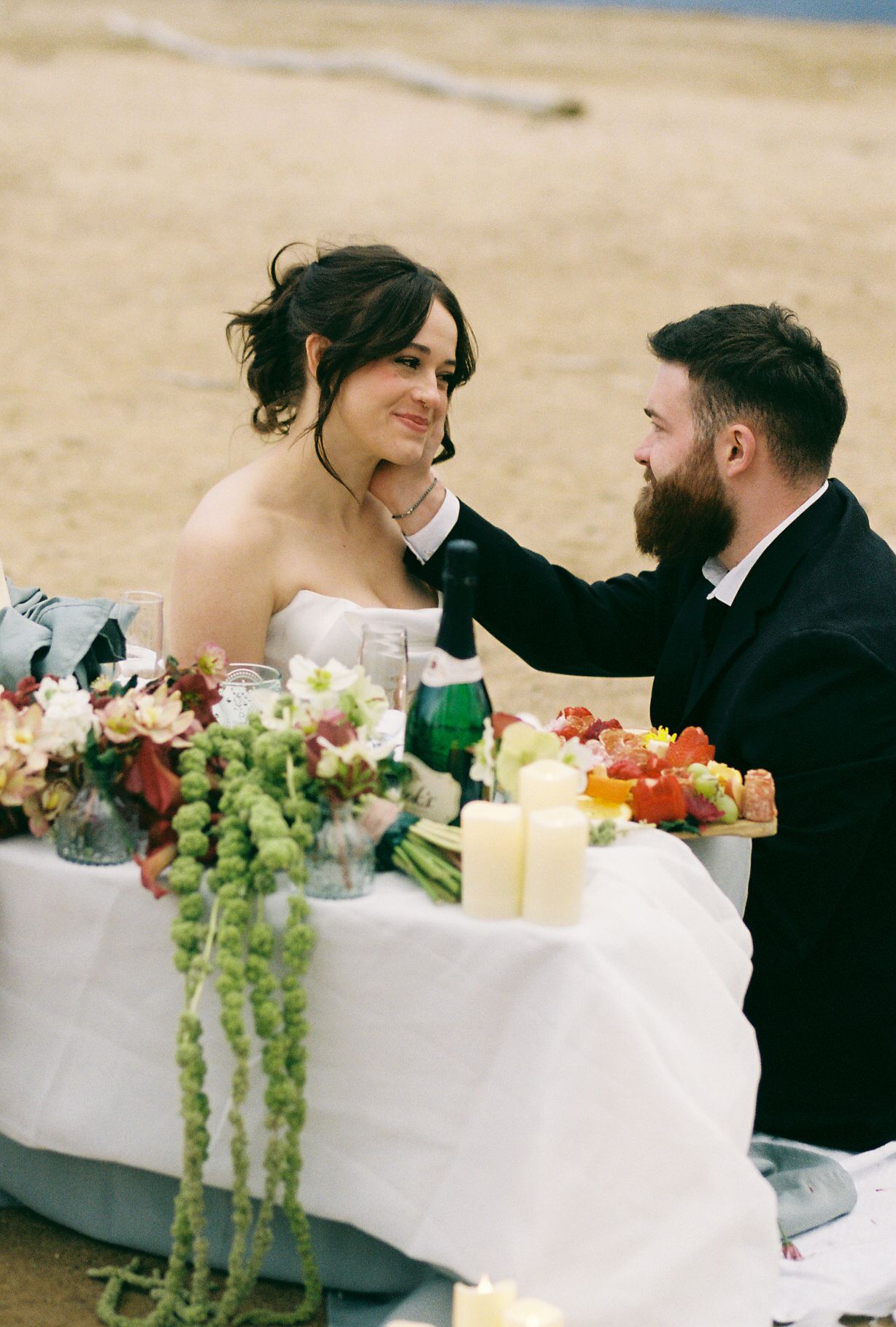 Wedding reception table decorated with fresh fruits, flowers and cascading greenery.