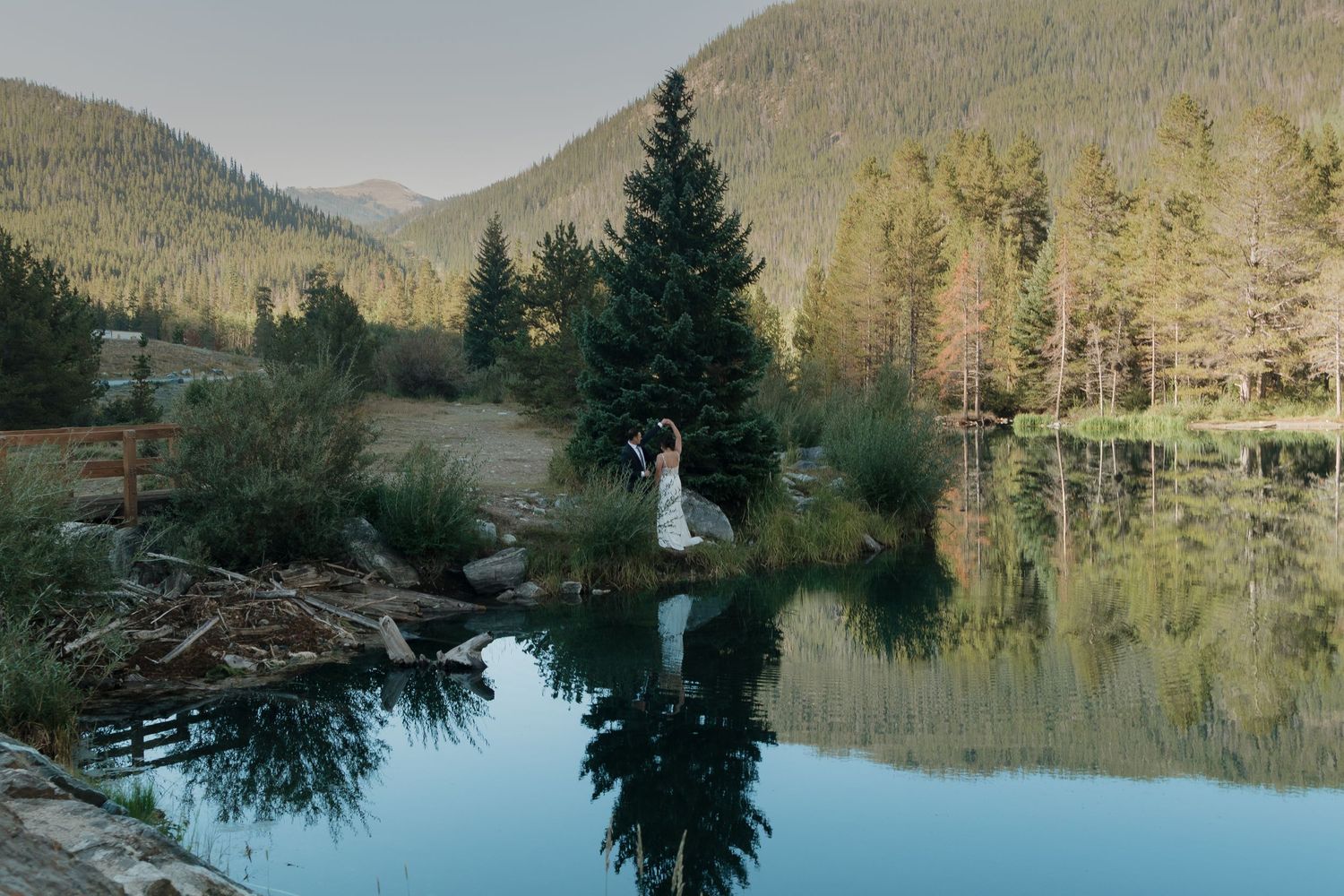 Panoramic view of a mountain lake surrounded by evergreen forests during a wedding celebration.