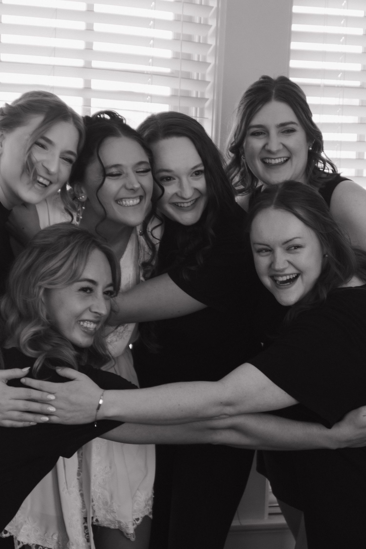 Group of friends sharing laughter and joy in black and white photography.