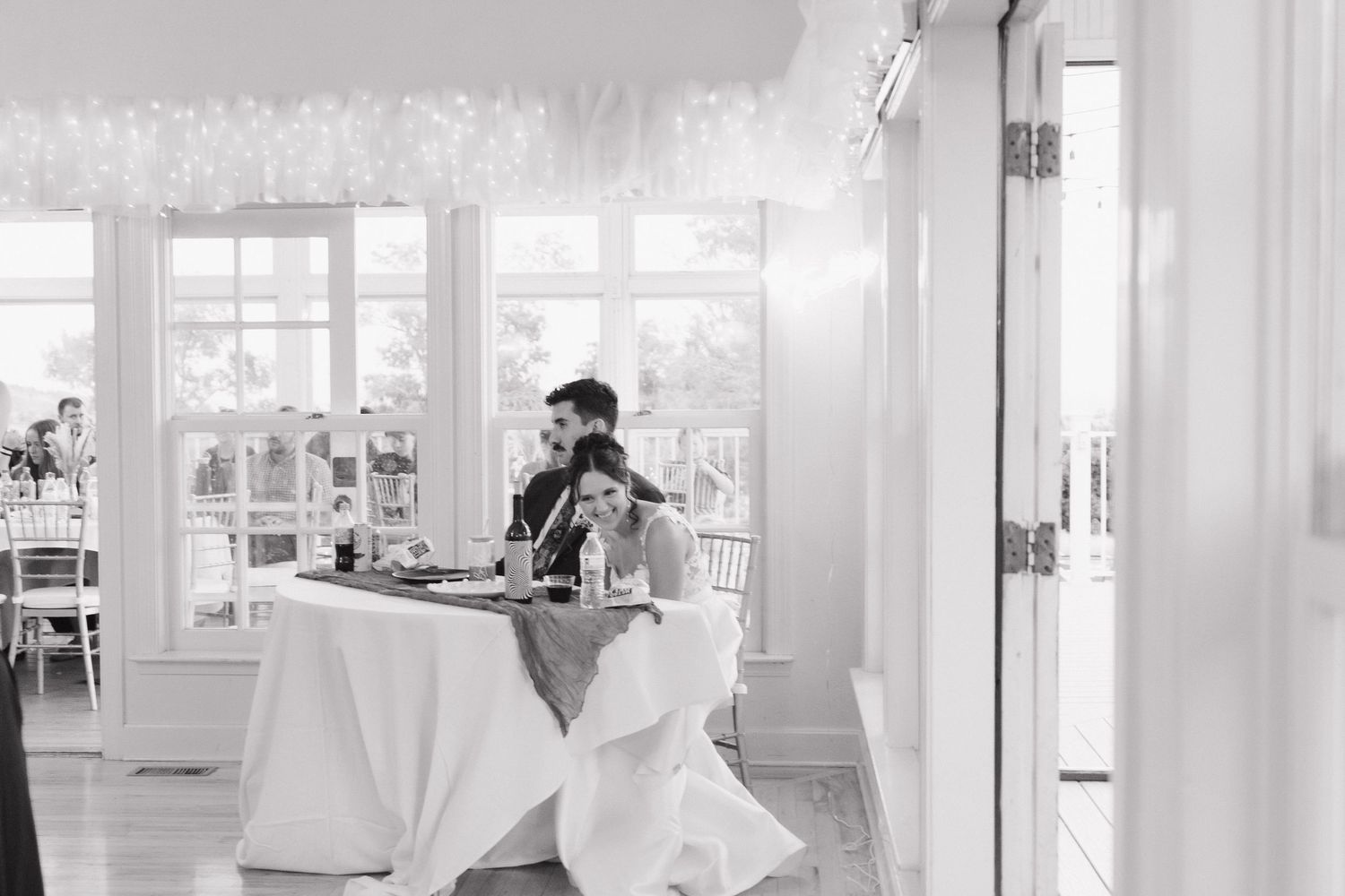Bright white reception hall with French doors and natural light streaming through multiple windows.