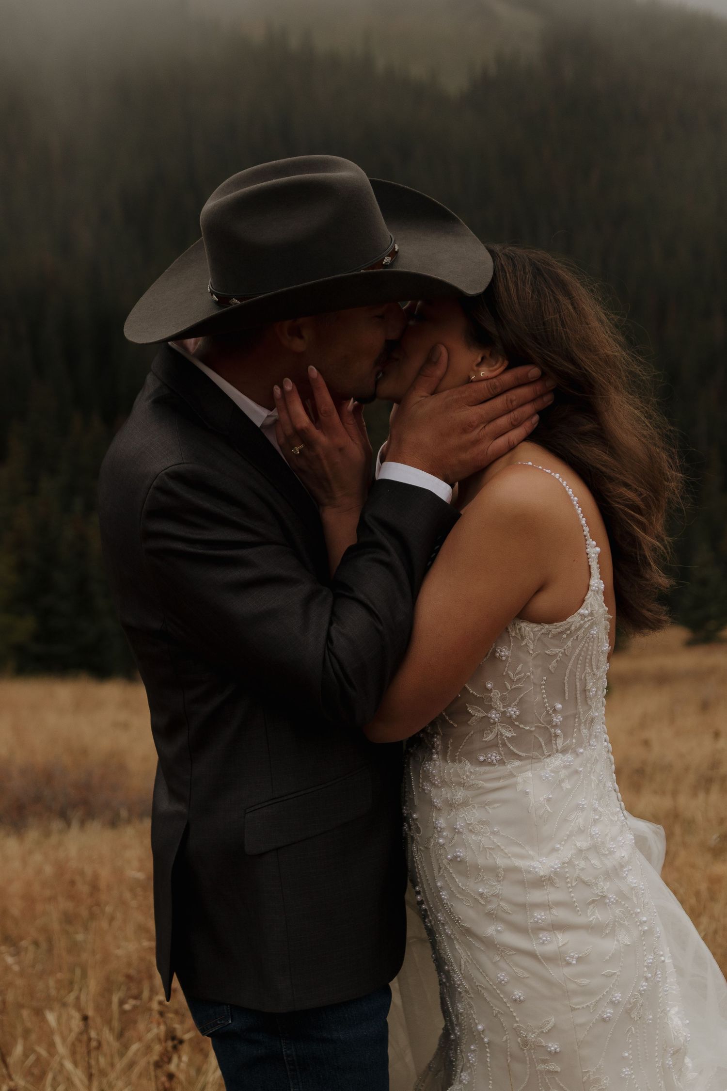 An intimate wedding moment captured in a rustic mountain setting at sunset.