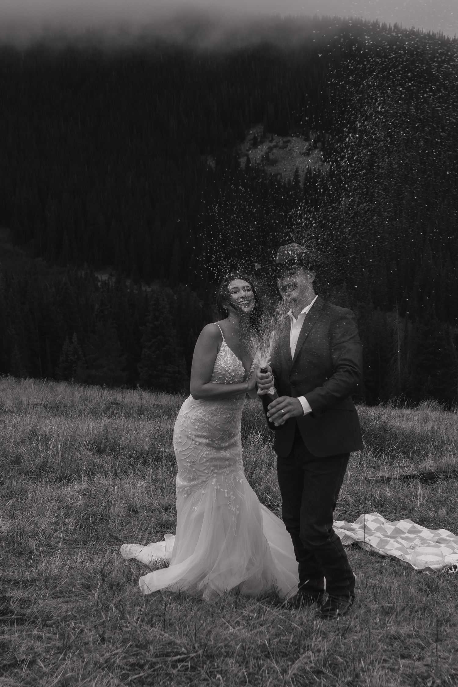 A black and white wedding photo sequence showing a couple dancing in a misty mountain meadow.