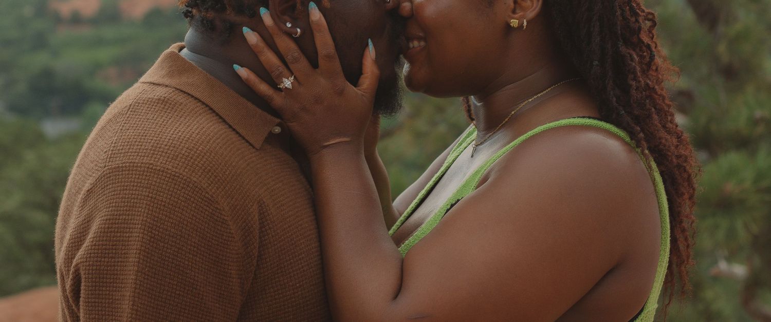 A tender intimate moment captured between two people in an outdoor setting during golden hour.