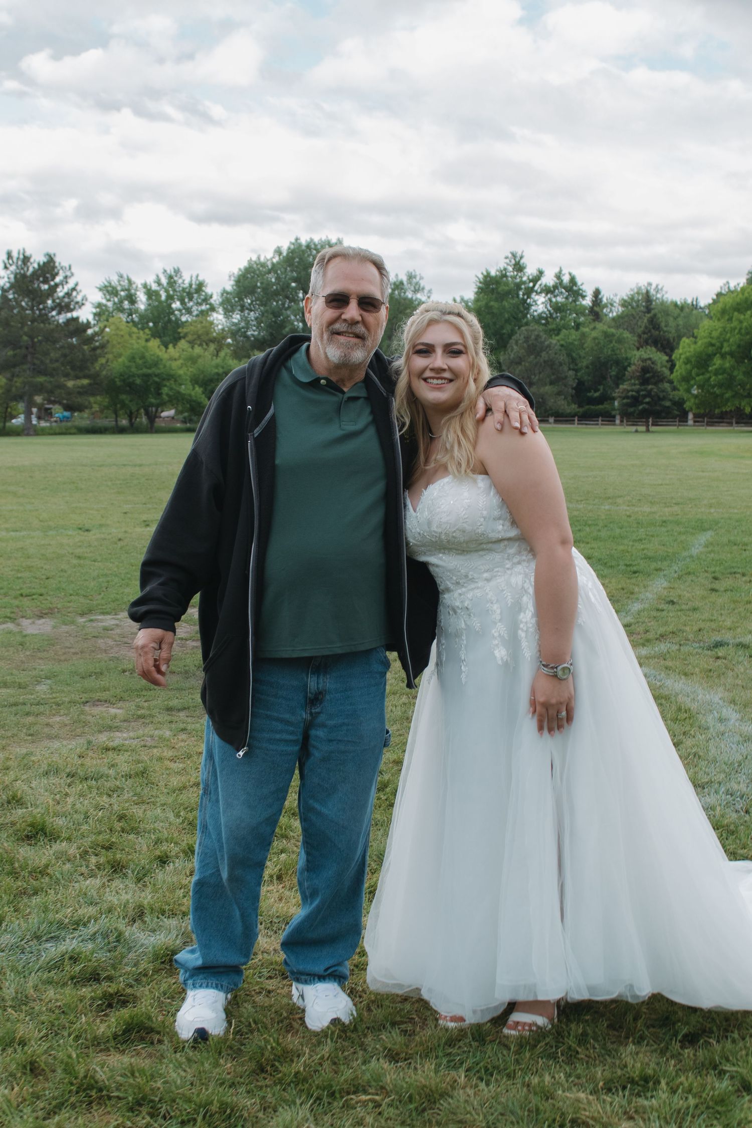 A heartwarming outdoor moment captured between people on a grassy field.