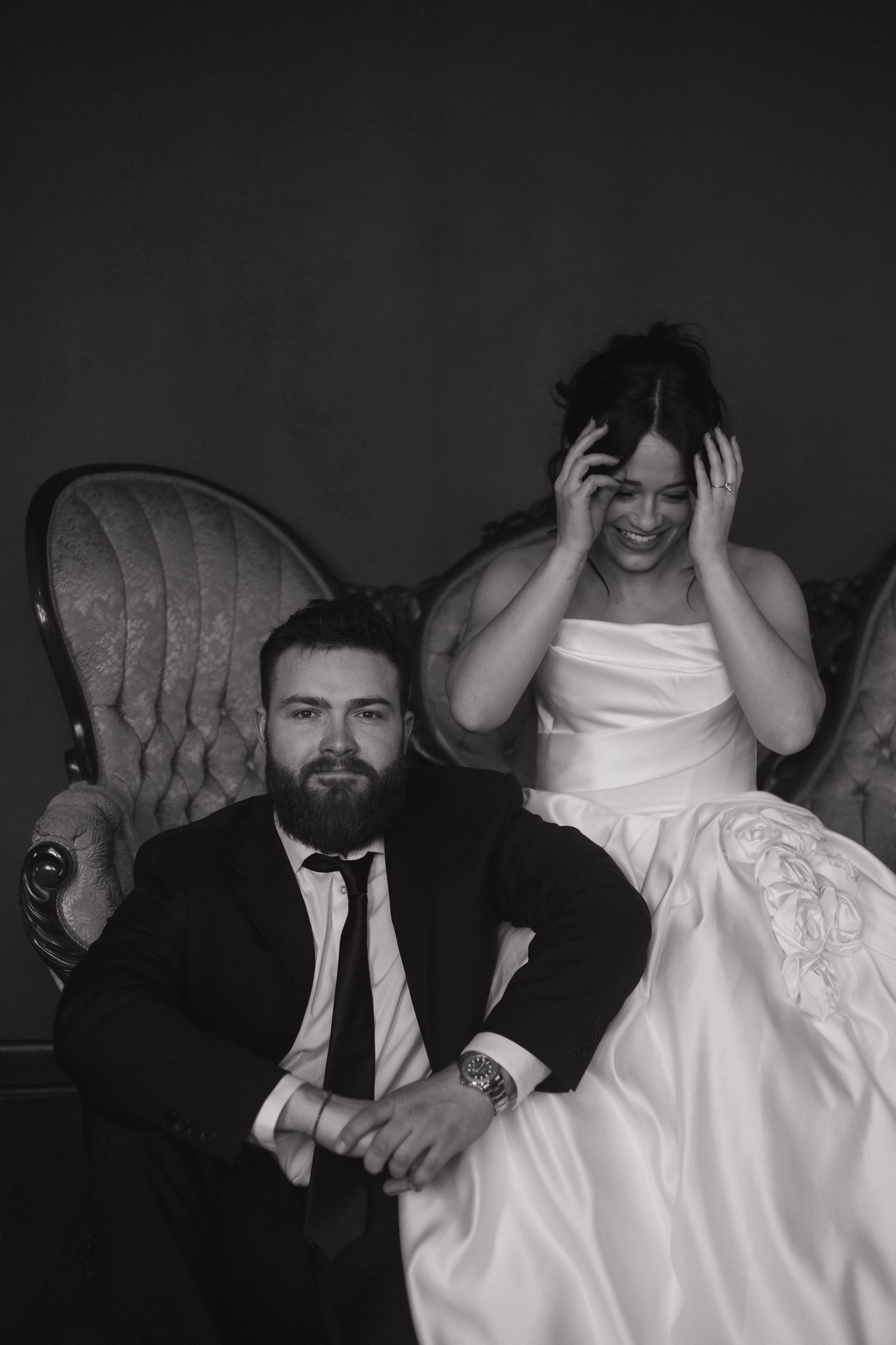 Black and white wedding portrait showing candid laughter and emotion.
