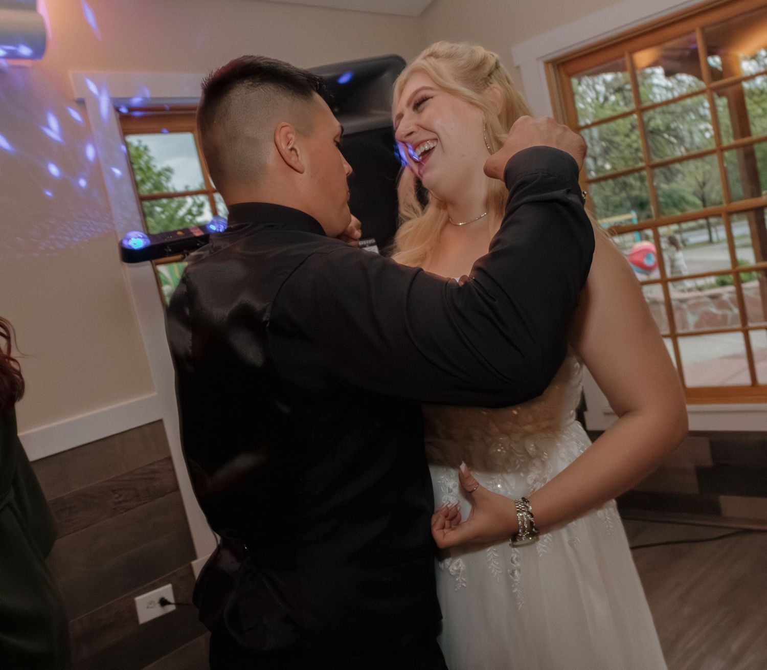 Couple sharing a joyful dance moment under disco lights at their wedding celebration.