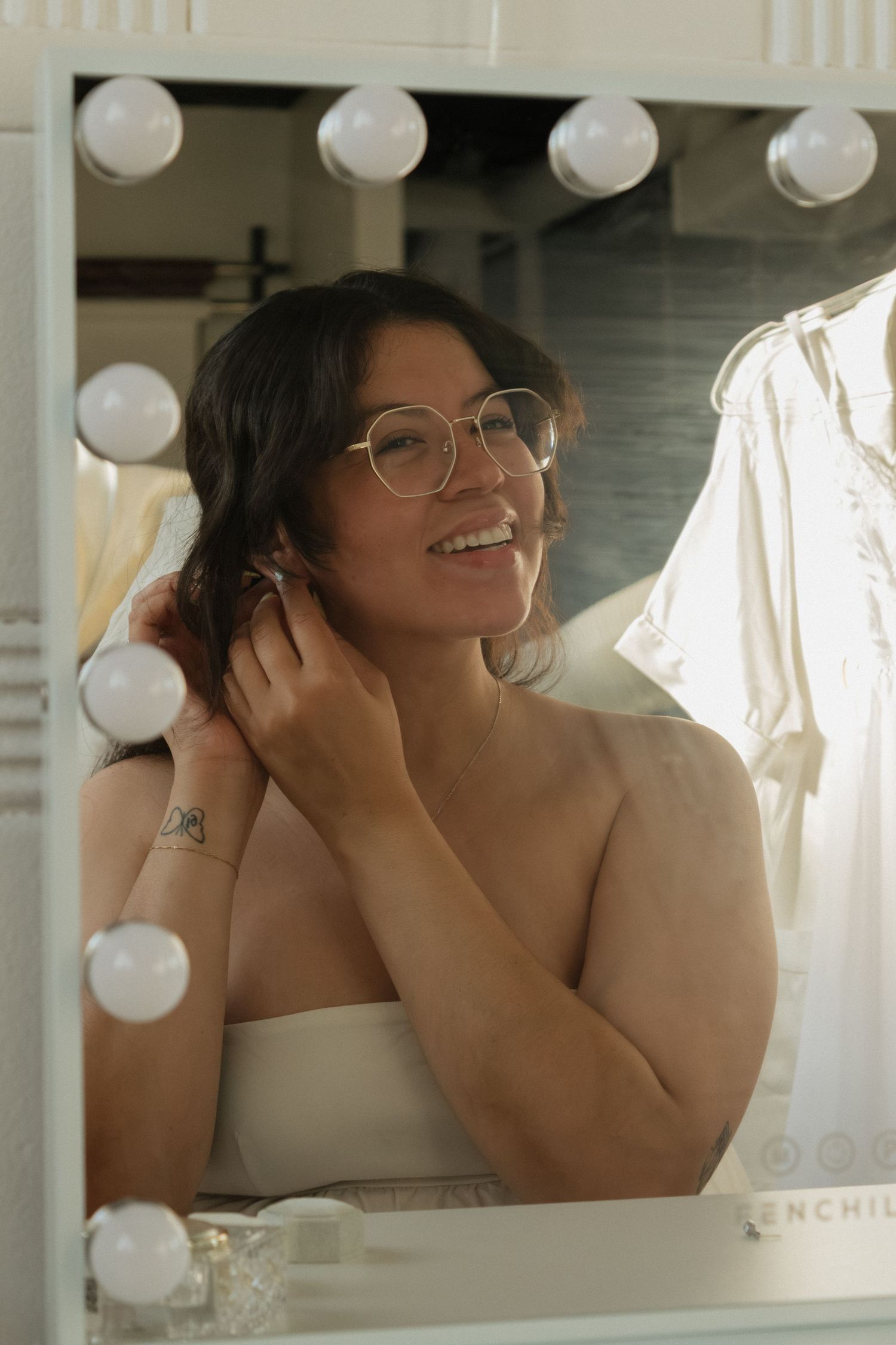 Romantic bridal portrait reflected in vanity mirror with soft lighting.