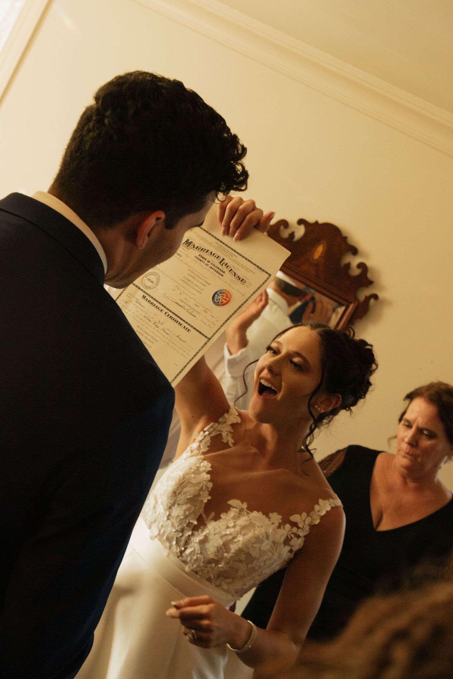 Wedding couple sharing a playful moment with marriage certificates.
