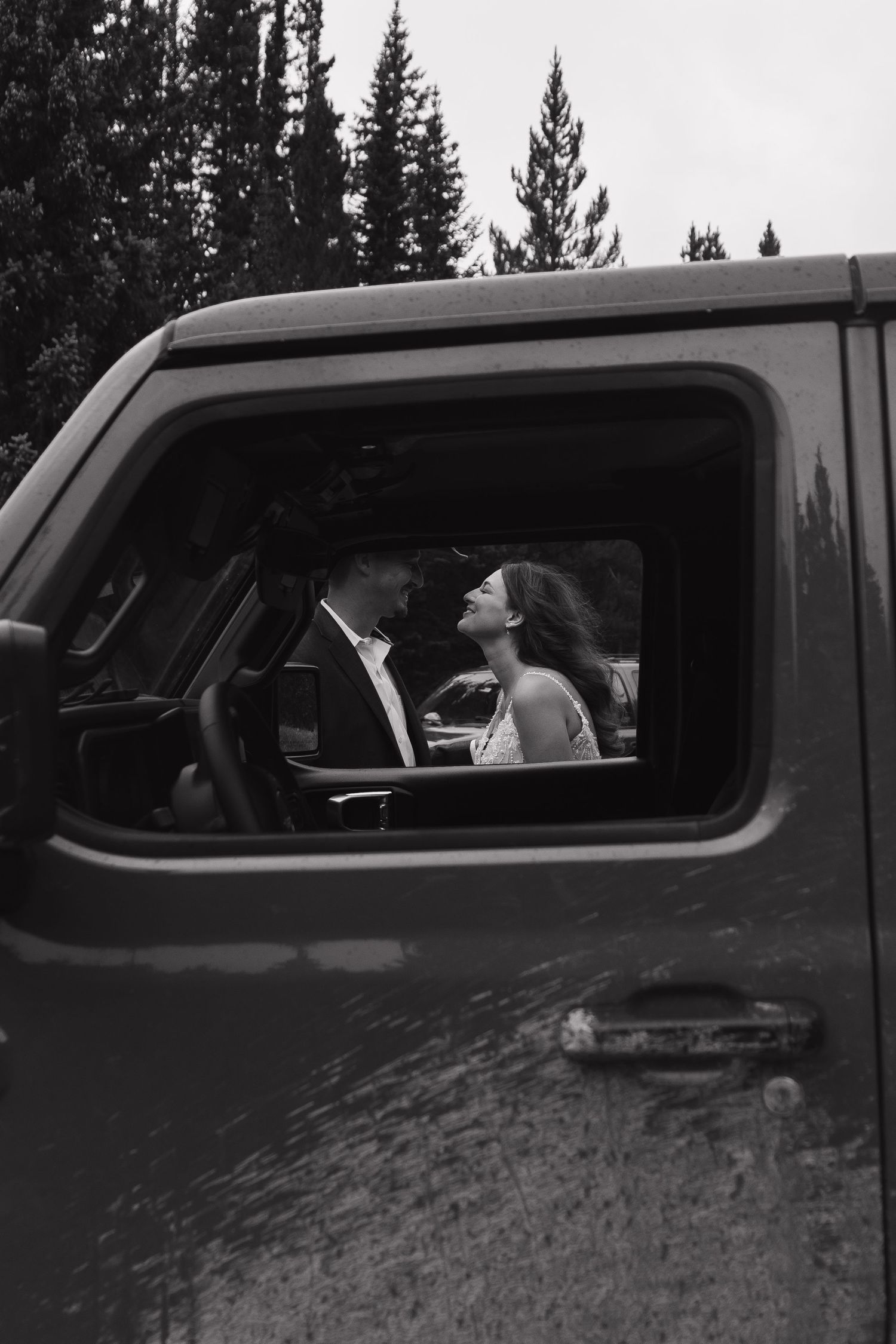 A romantic black and white moment captured through a truck window.