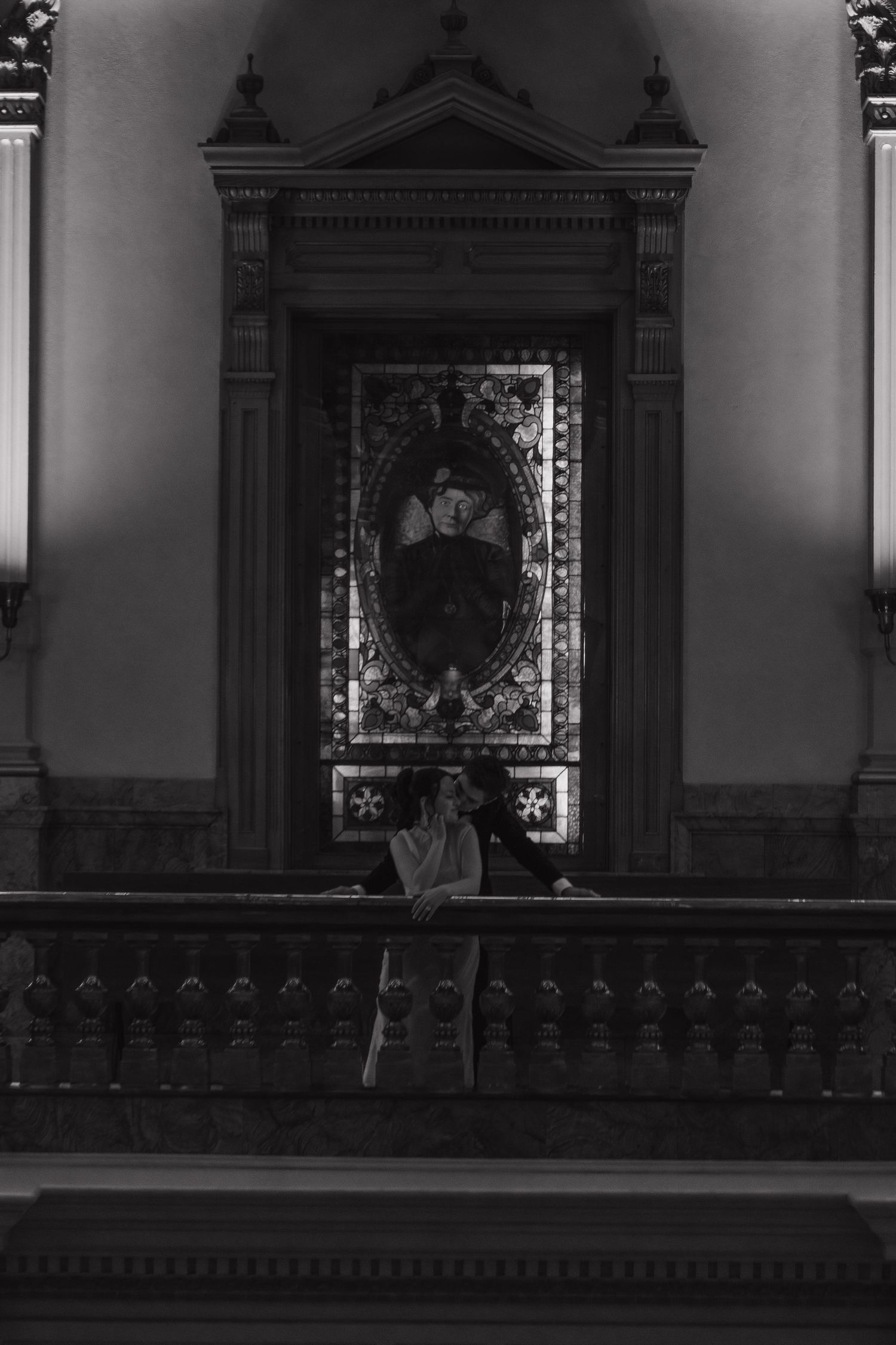 A dramatic black and white photo of an ornate altar in a historic building.