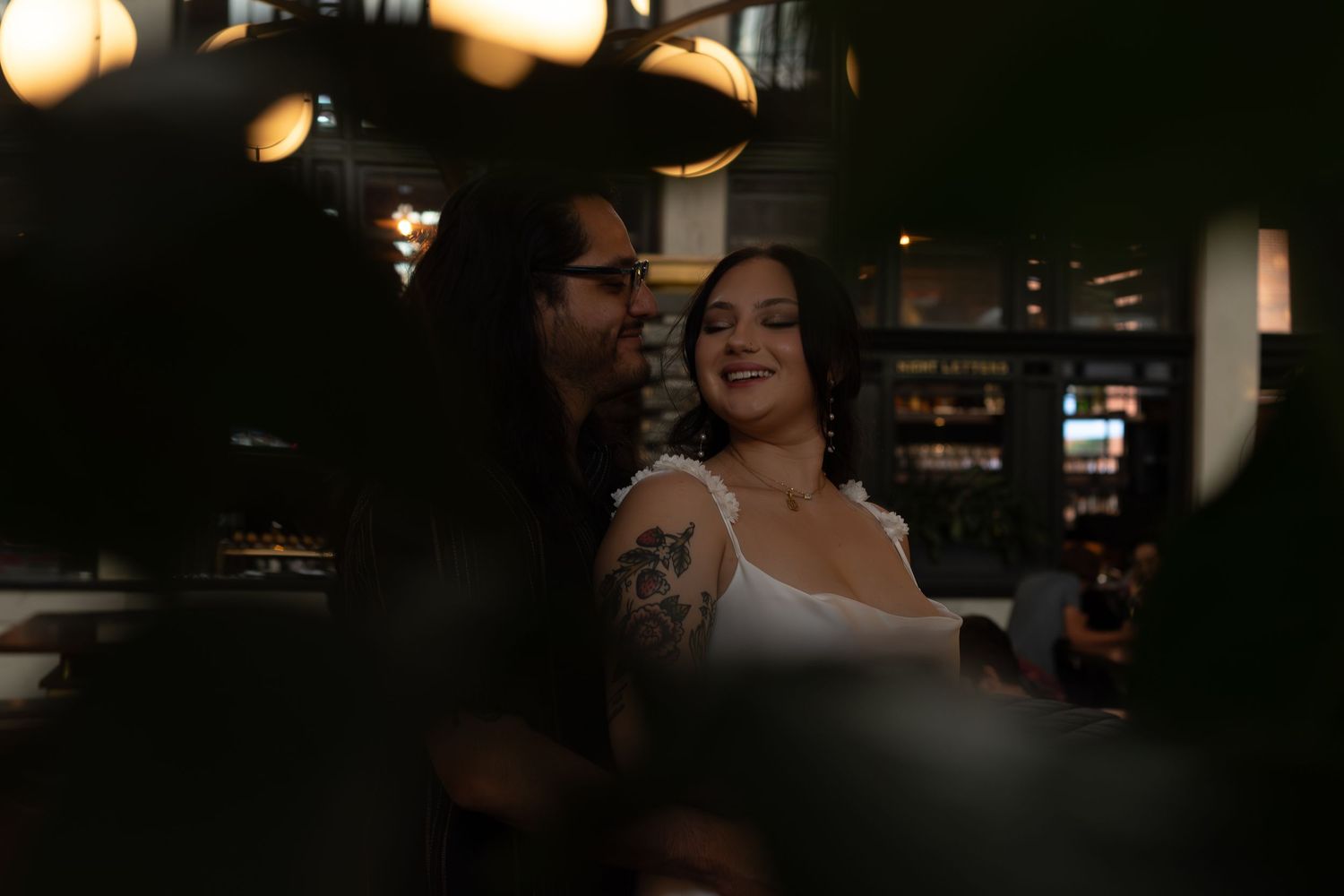 A couple shares an intimate moment in a dimly lit interior space.