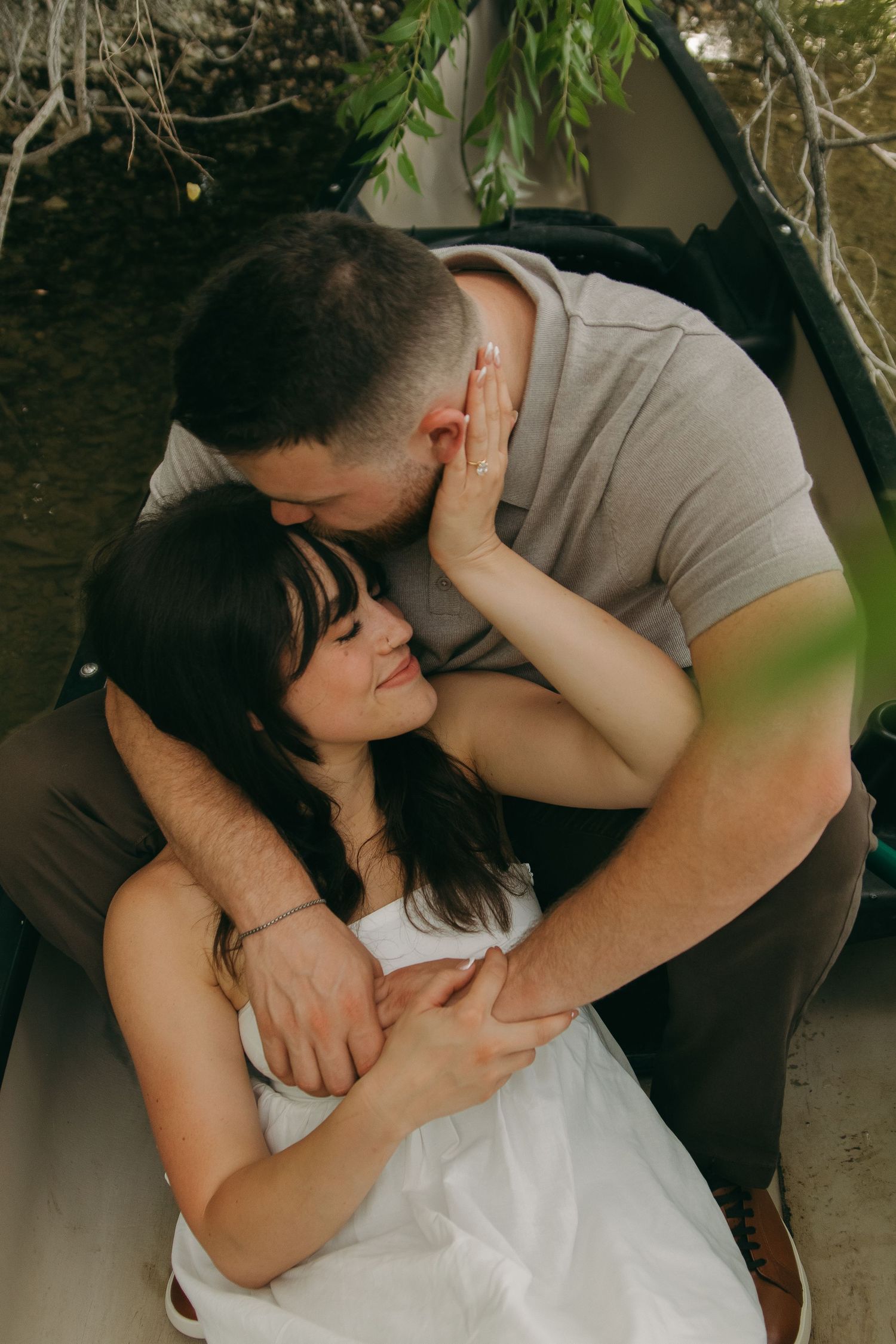 A romantic outdoor photoshoot sequence showing a couple embracing and sharing intimate moments under natural foliage.