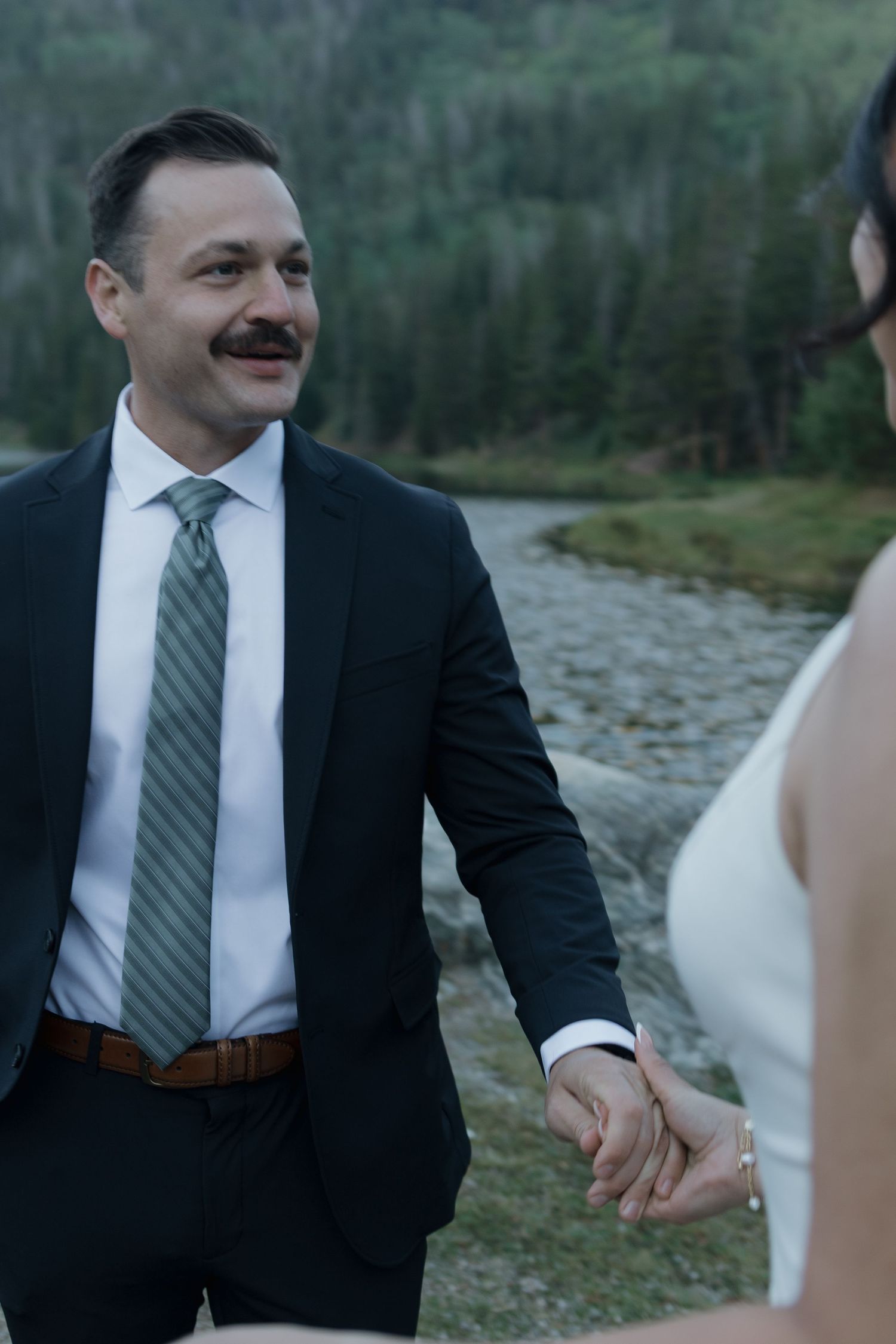 A tender wedding moment captured against a scenic mountain backdrop.
