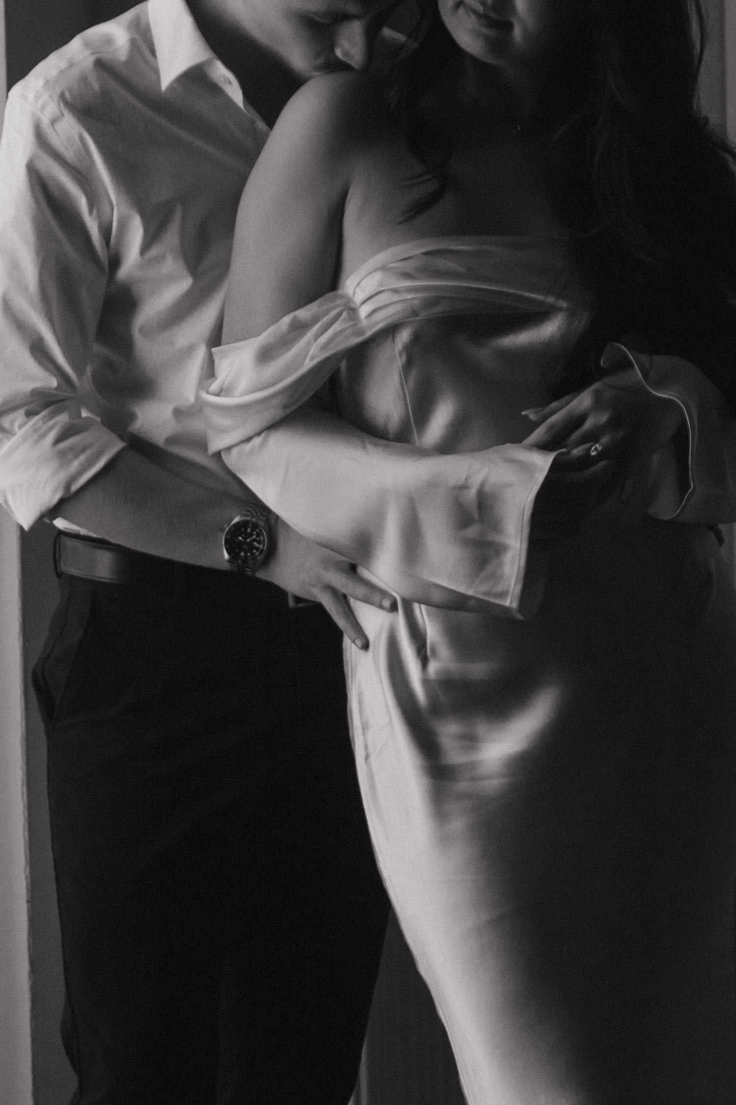 Black and white artistic portrait showing intimate moments in dramatic lighting.