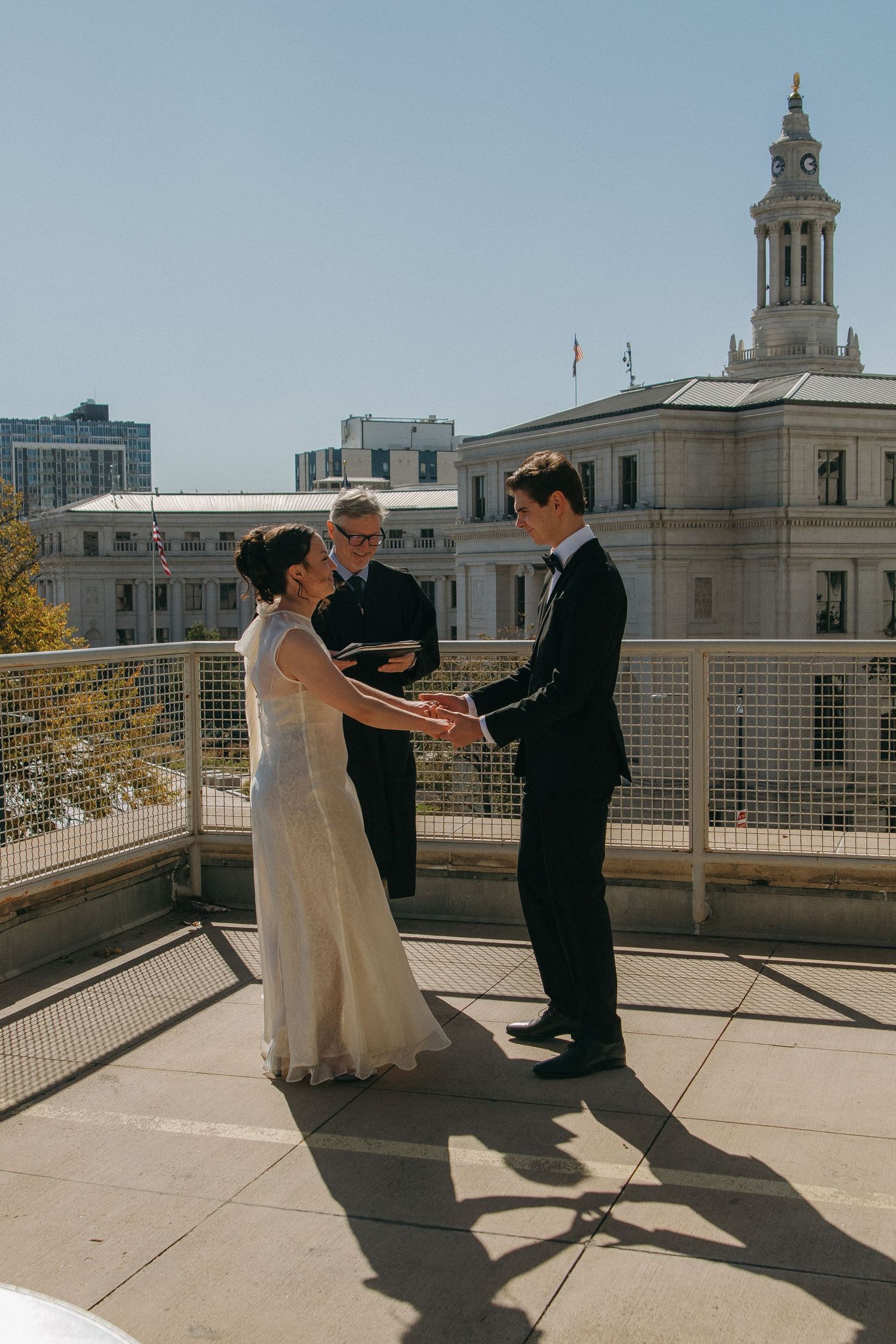 Rooftop terrace of a historic building with city architecture and blue sky in the background.