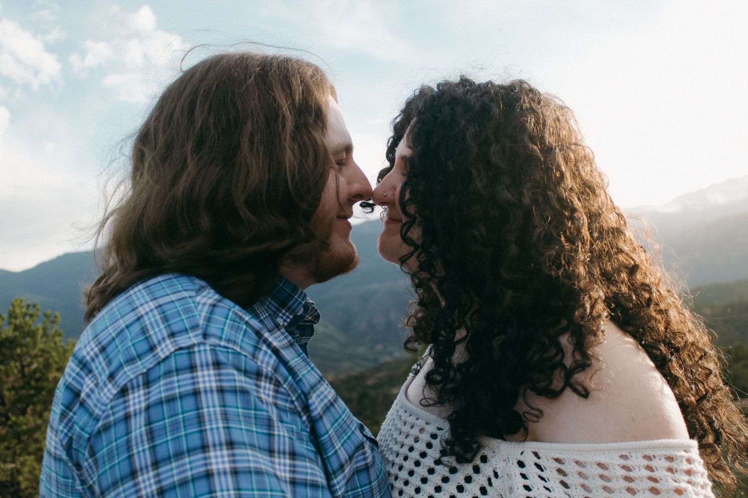 A couple sharing an intimate moment on a mountain overlook at sunset.