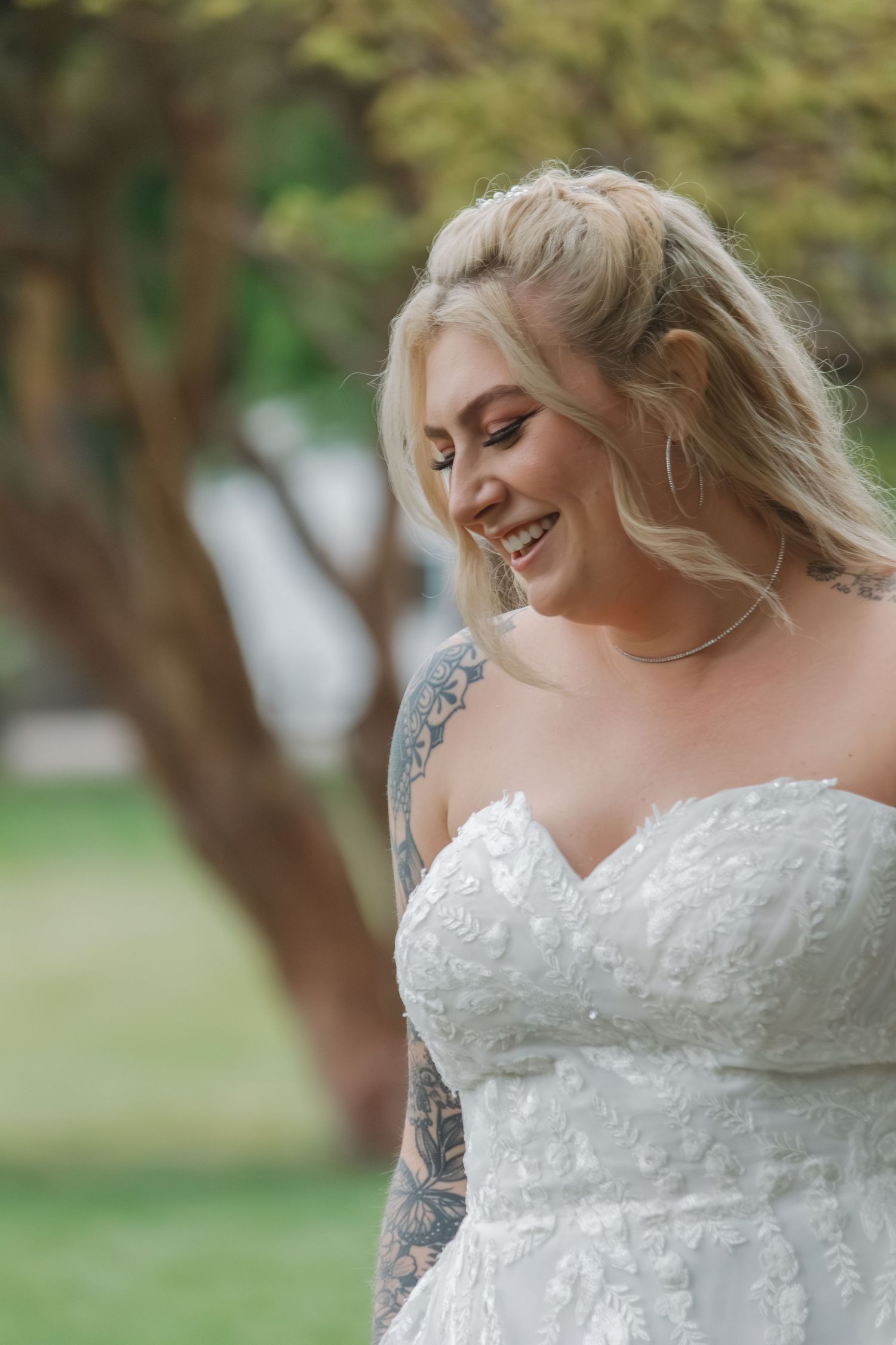 Joyful candid moments captured in lace wedding dress against garden backdrop.