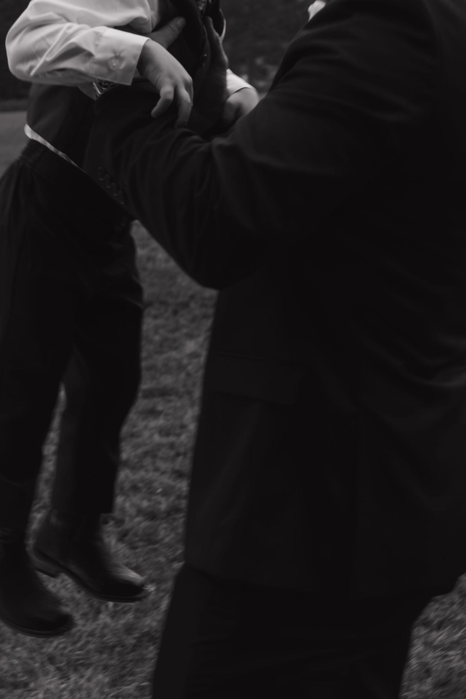 Black and white detail shot of formal wear against grass backdrop.