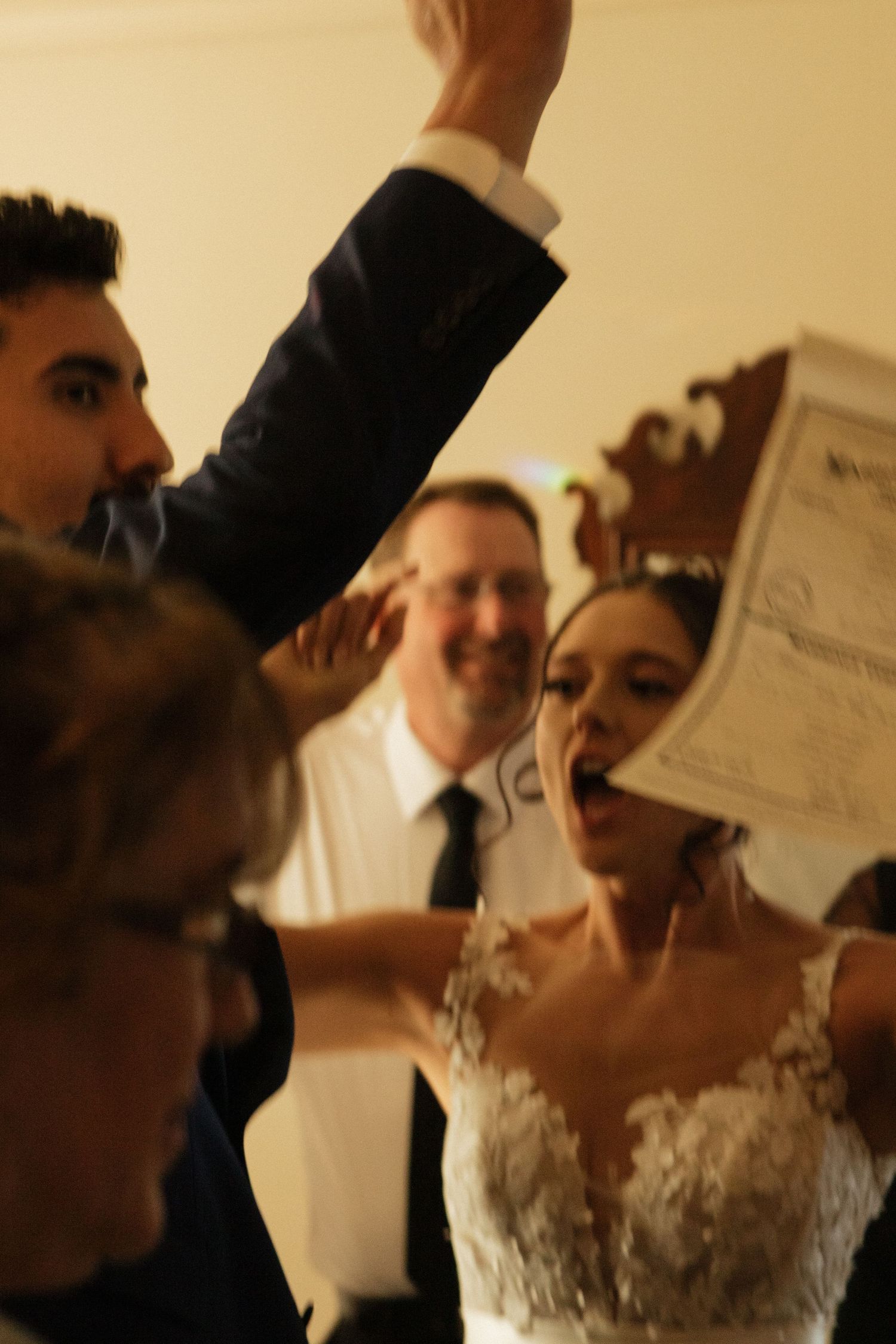 Celebratory moment with marriage certificate being held up during reception.
