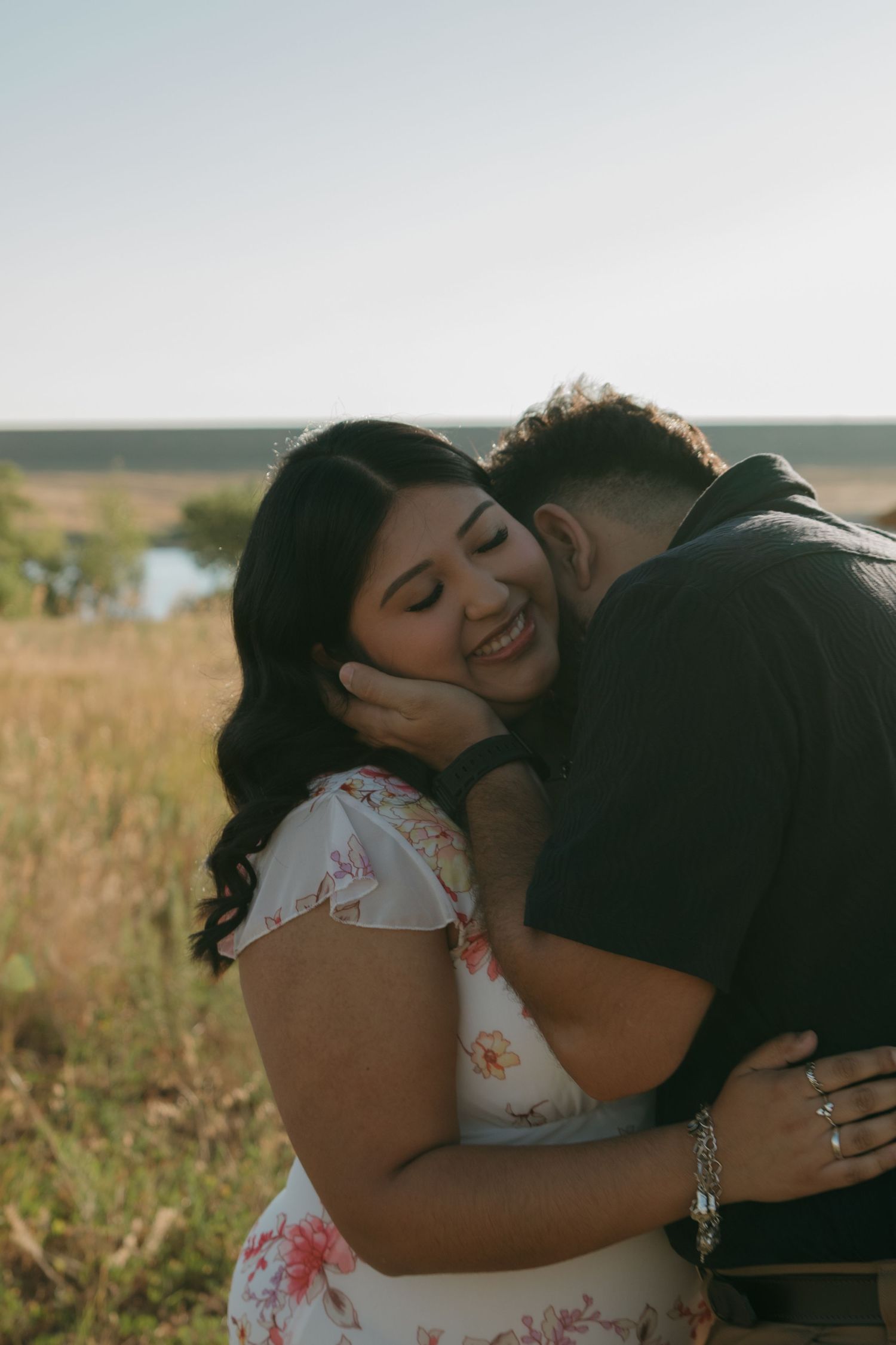 A tender moment captured between a couple in a sun-drenched field at golden hour.