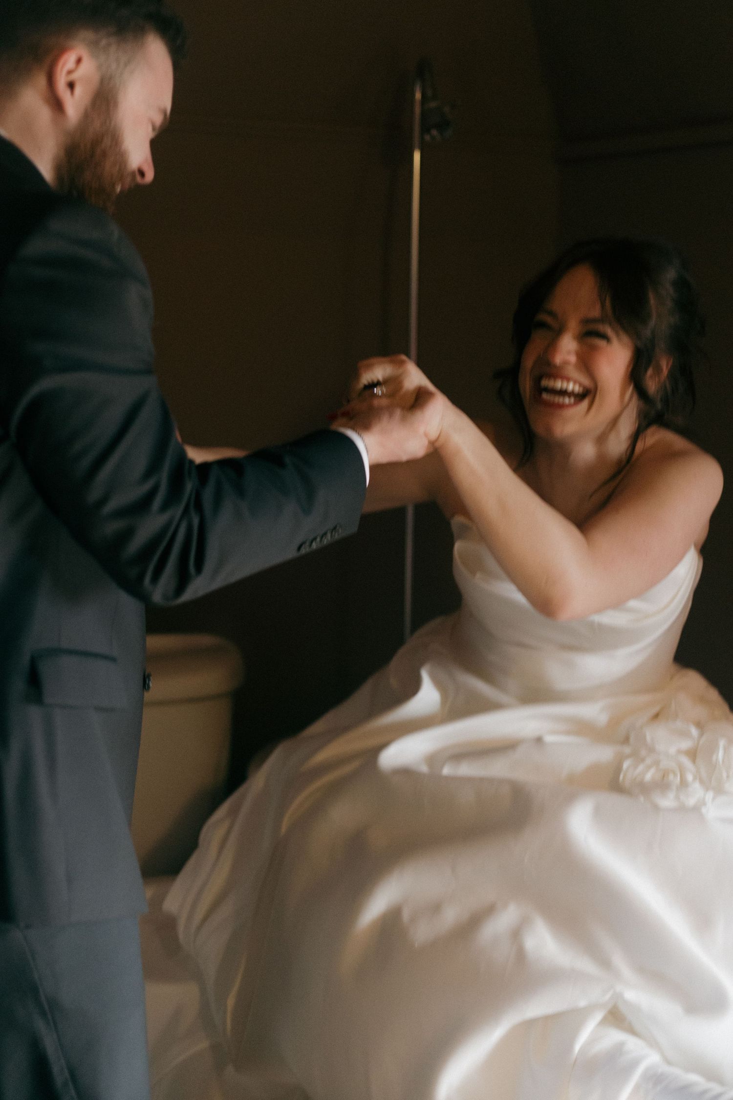 A joyful moment between newlyweds as they hold hands and laugh together.