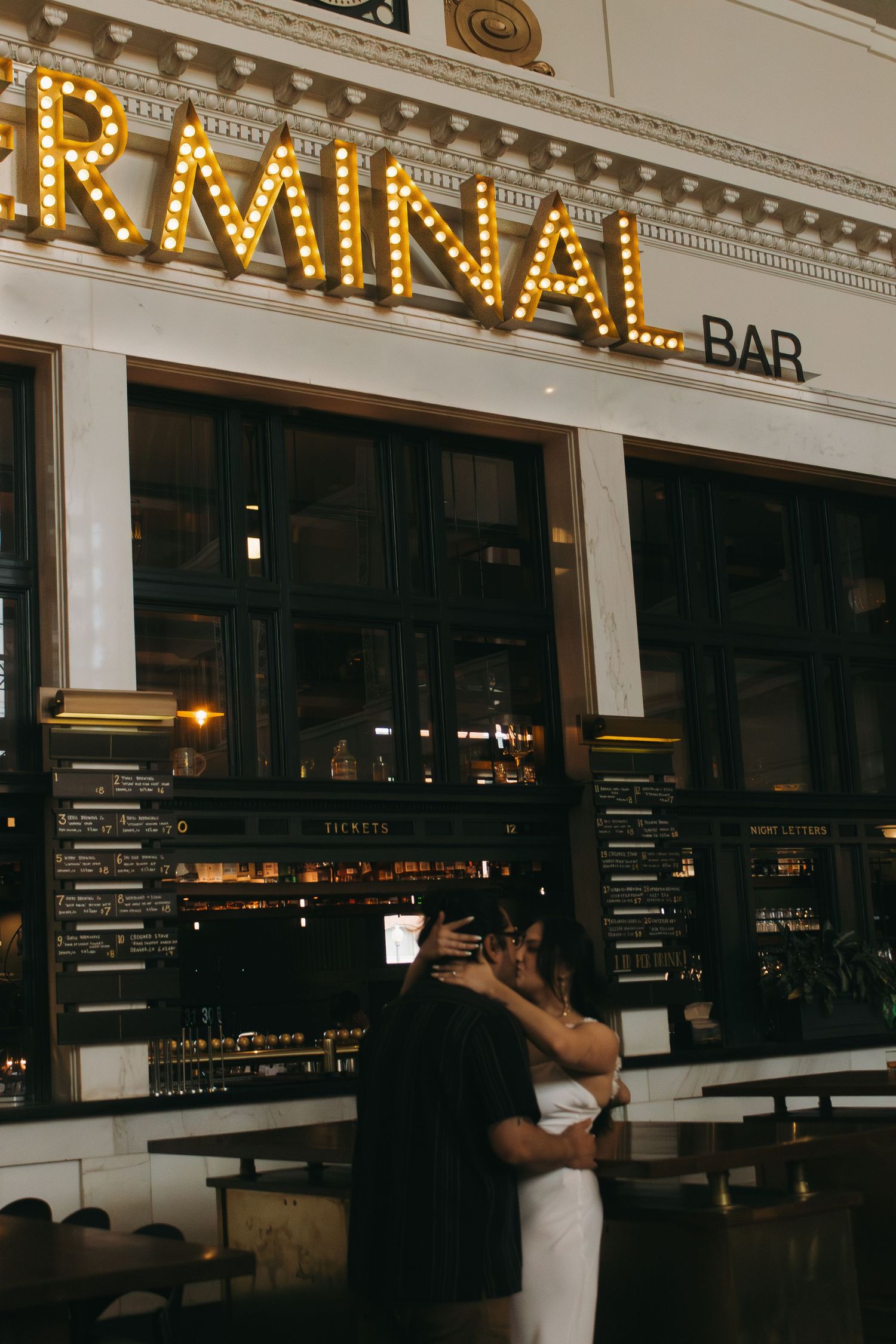 Illuminated vintage-style bar signage with ornate architectural details and decorative molding.