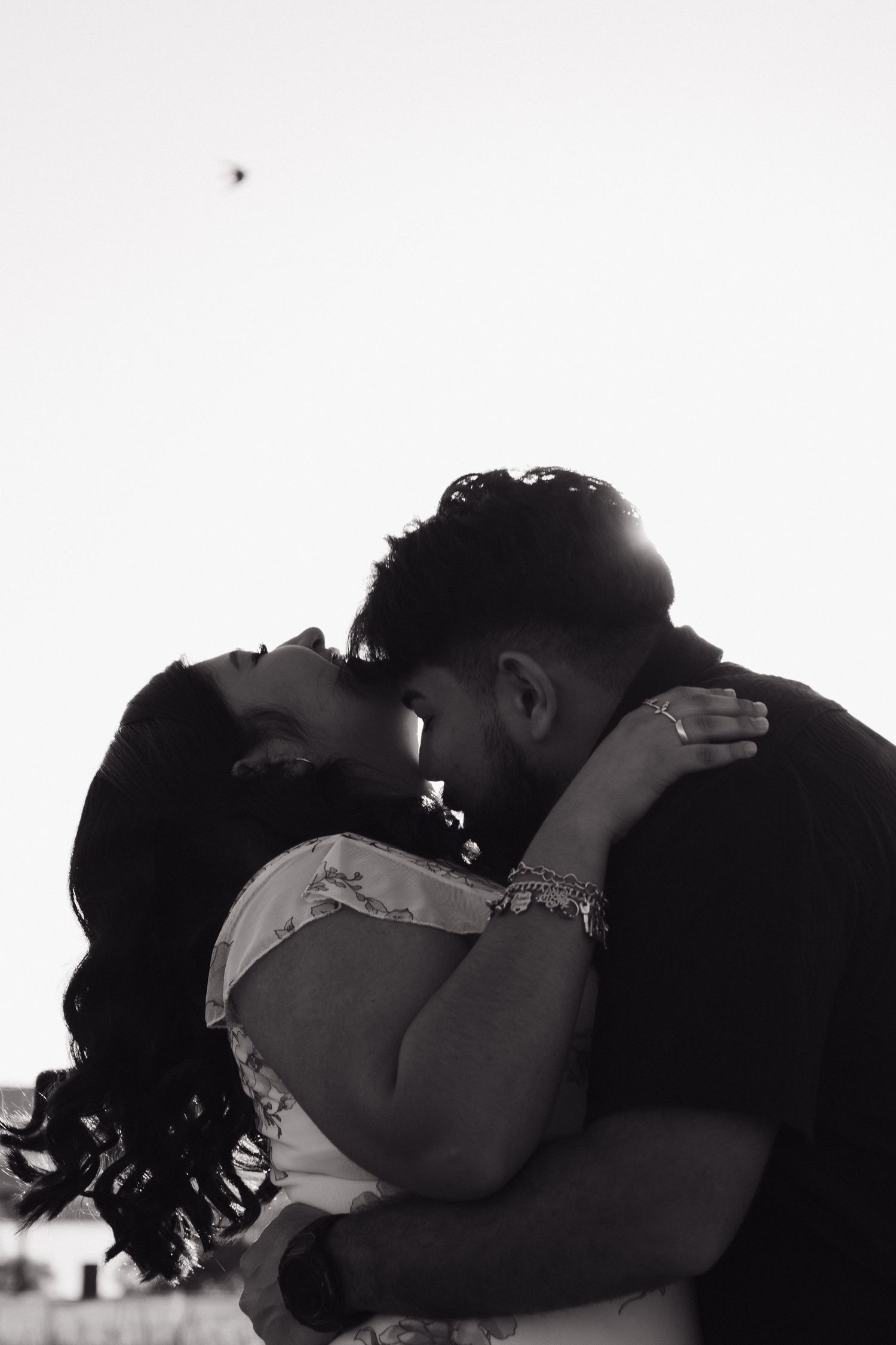 A dramatic black and white photo captures an intimate moment between a couple.