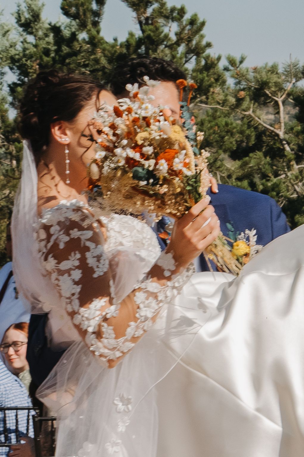 Joyful wedding celebration moment with confetti toss in natural outdoor setting.
