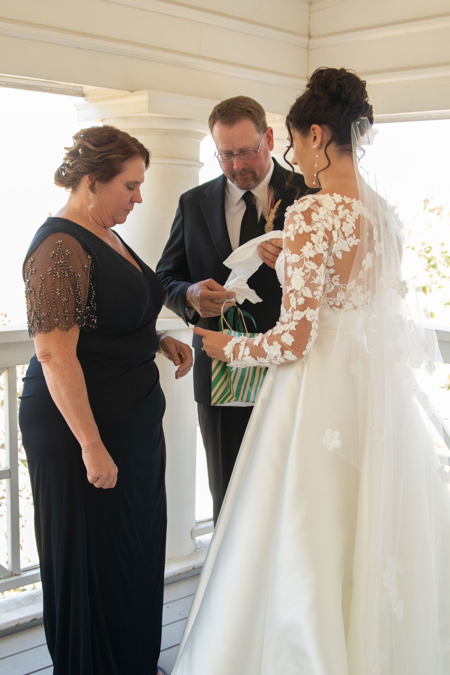 Final dress preparations take place in a sunlit room before a wedding ceremony.