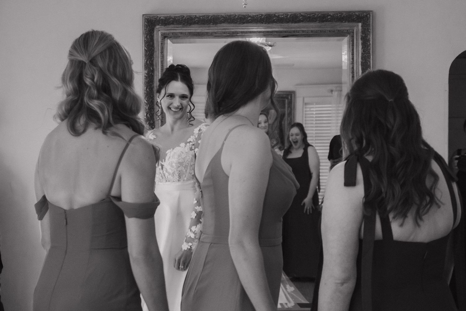 Black and white photo of wedding party getting ready in formal attire.