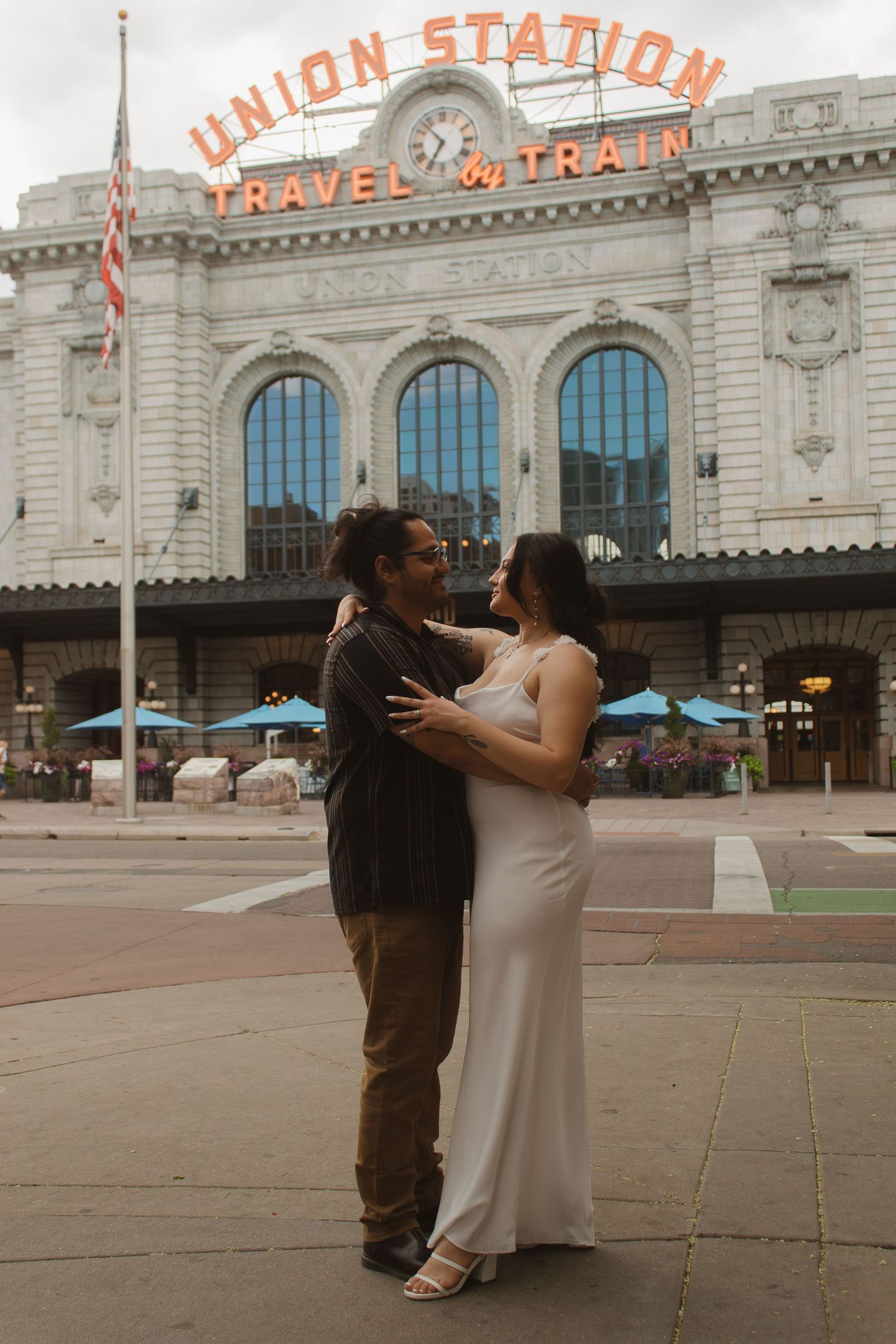 A tender moment between a couple in front of the historic Union Station Travel Train building in Denver.